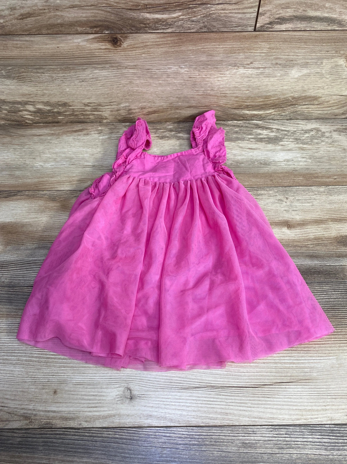 Flat lay of pink Cat & Jack toddler tulle dress showcasing eyelet ruffle straps on wood background