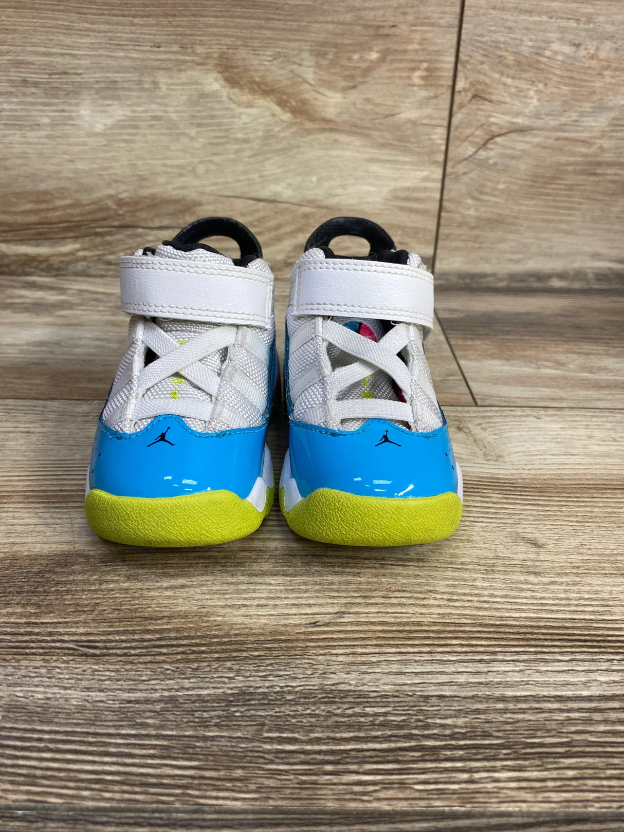 Front view of Air Jordan 6 Rings TD toddler sneakers size 5C showcasing light blue patent leather toe, yellow outsole, white Velcro strap and Jumpman logo on wood floor