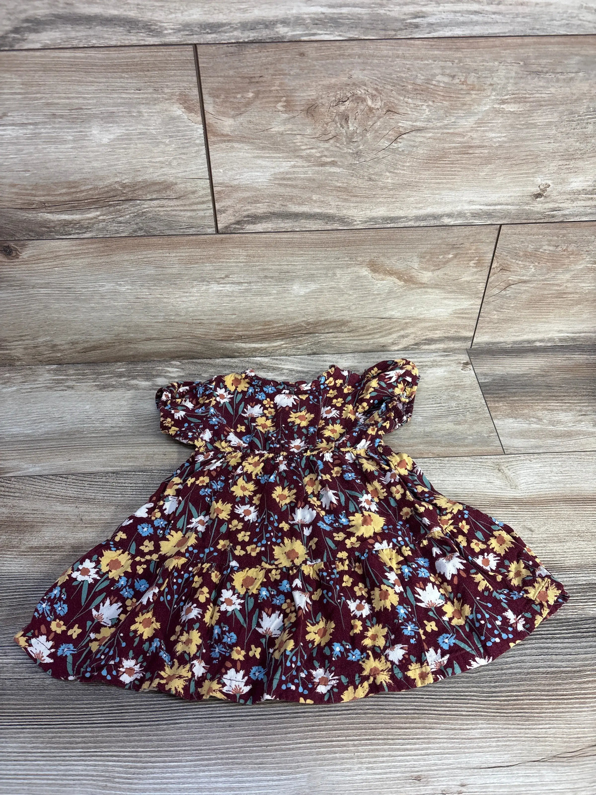 Front view of Wonder Nation floral henley dress showcasing burgundy floral print and flared skirt on a wood-look floor