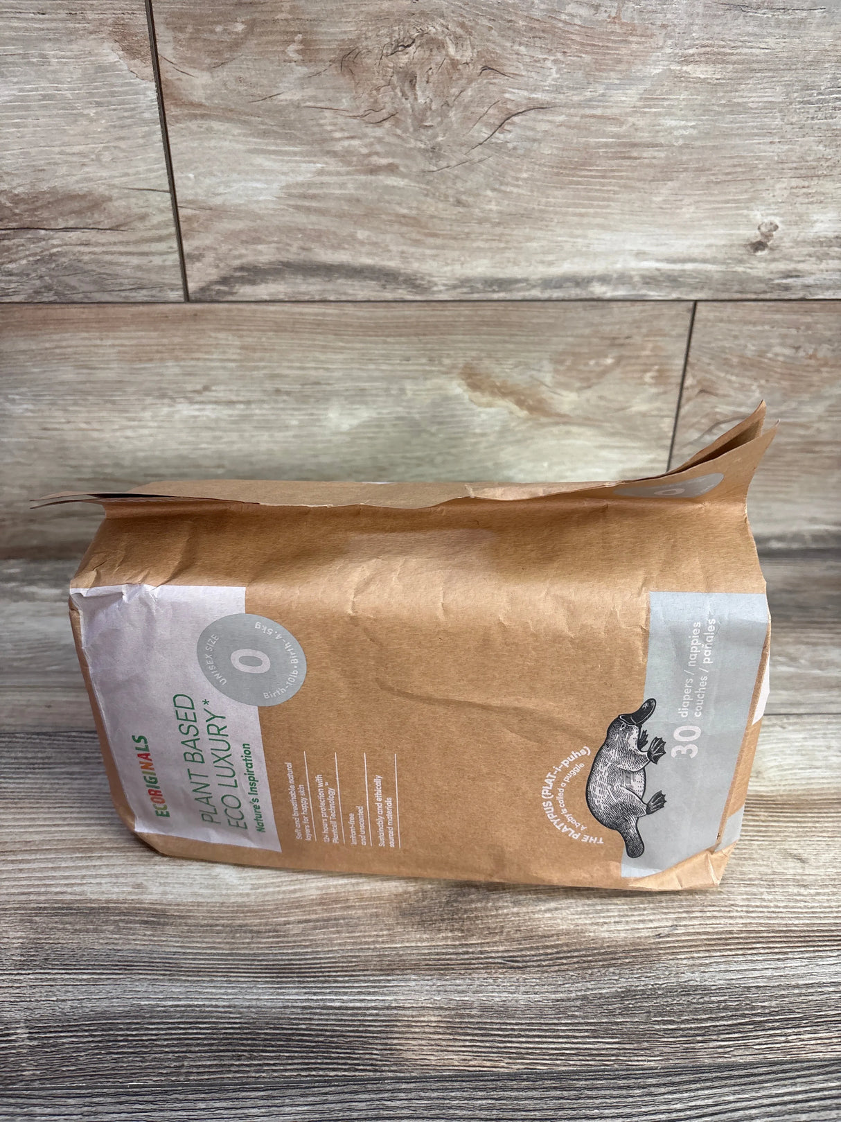 EcoOriginals plant based diapers pack with platypus design on wooden surface