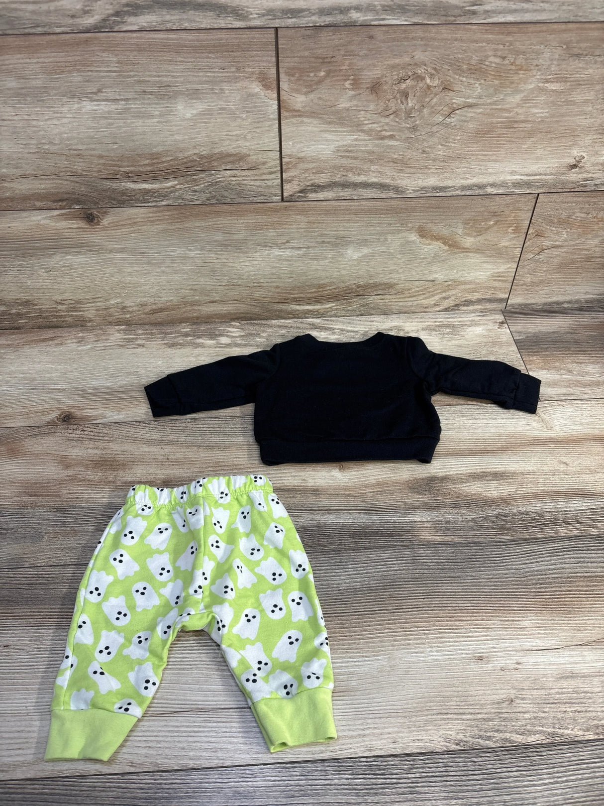 Black baby sweater with lime green ghost print pants, kids Halloween outfit set on wood floor