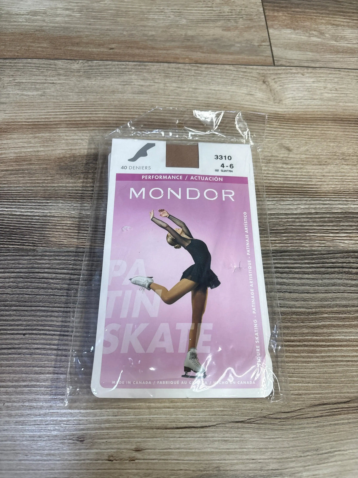 Front view of NEW Mondor footed skate tights 3310 in suntan, packaged on a wood surface