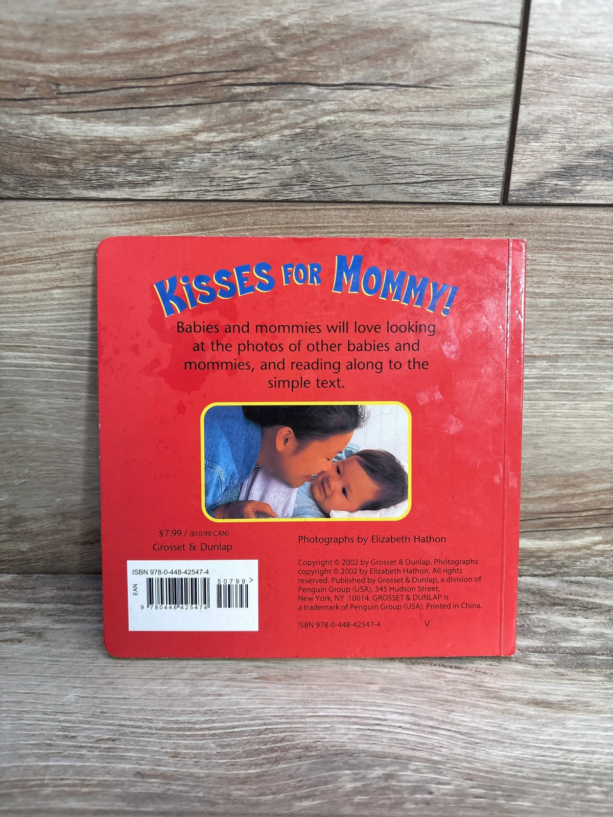 Back cover of "Kisses for Mommy!" baby board book with photo of mother and baby and red background