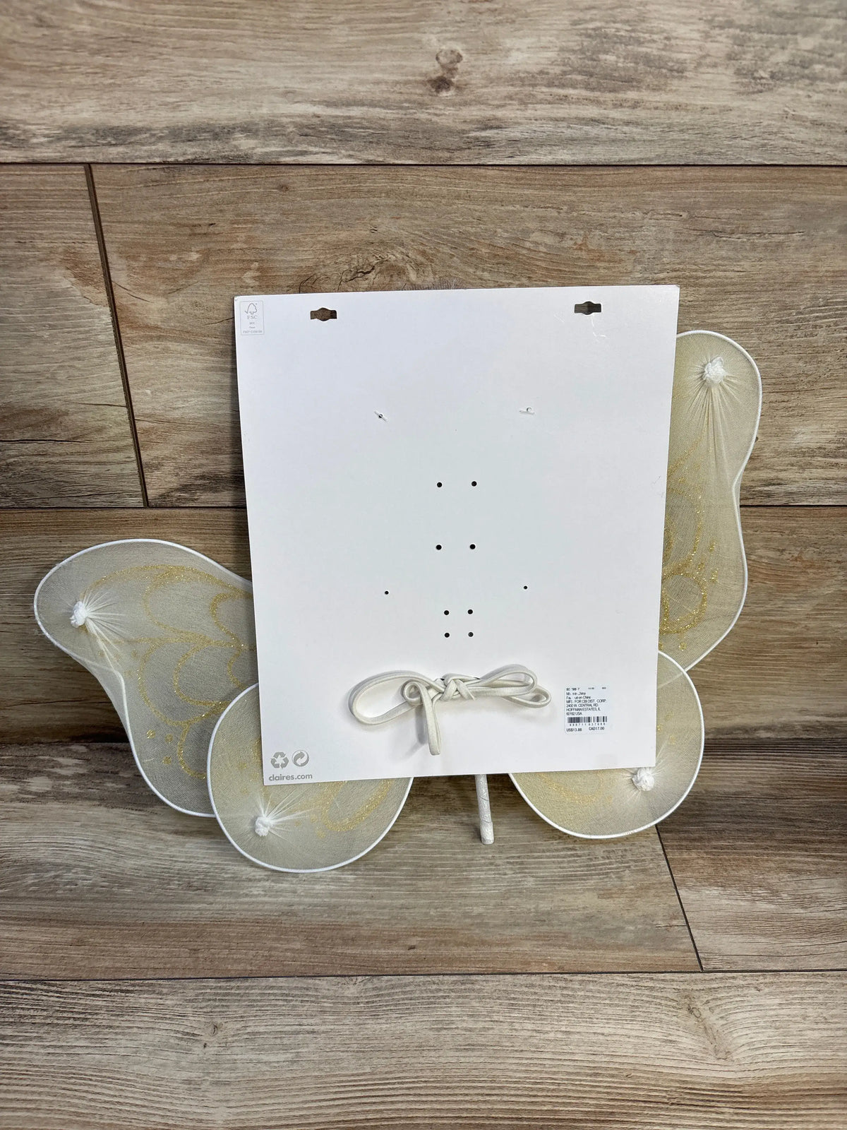 Rear view of Claire’s Club 2pc Butterfly Wings & Wand showcasing translucent wings with gold patterns on a wood floor