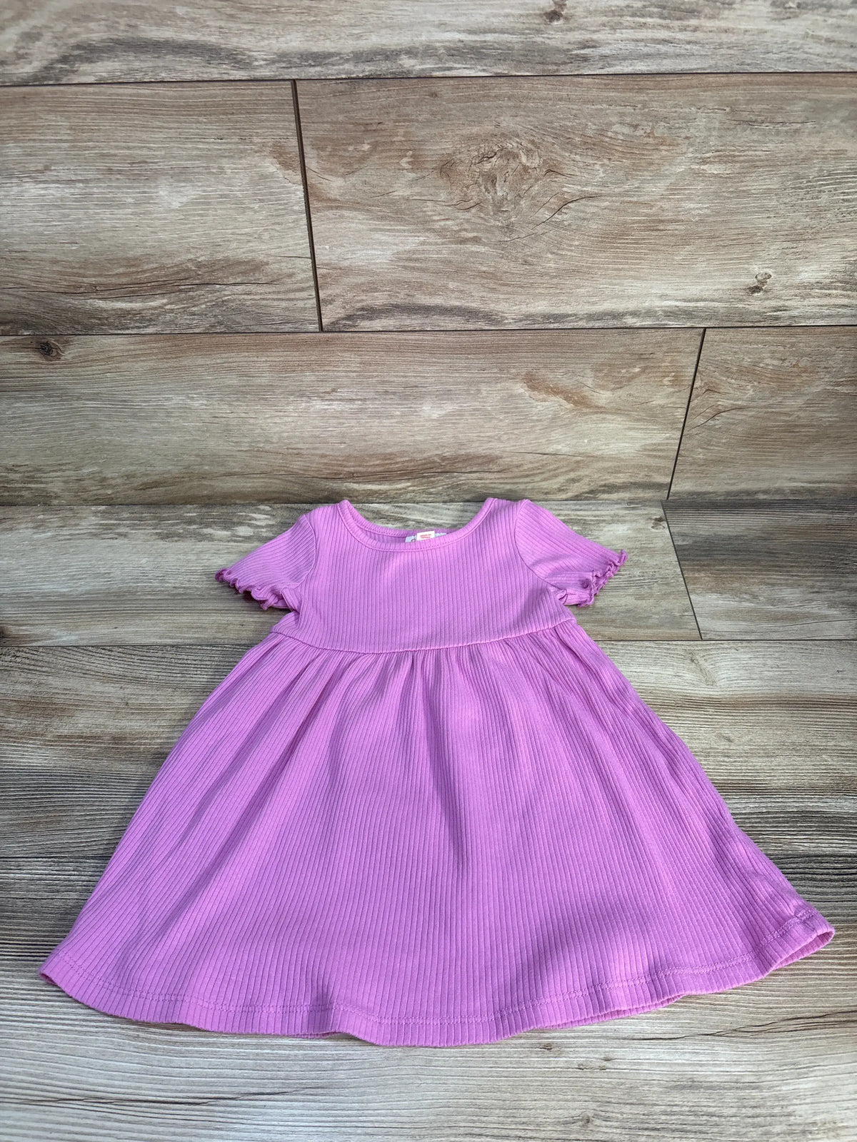 Front view of Cat & Jack ribbed dress showcasing ruffled short sleeves and a gathered skirt on a wood-look floor