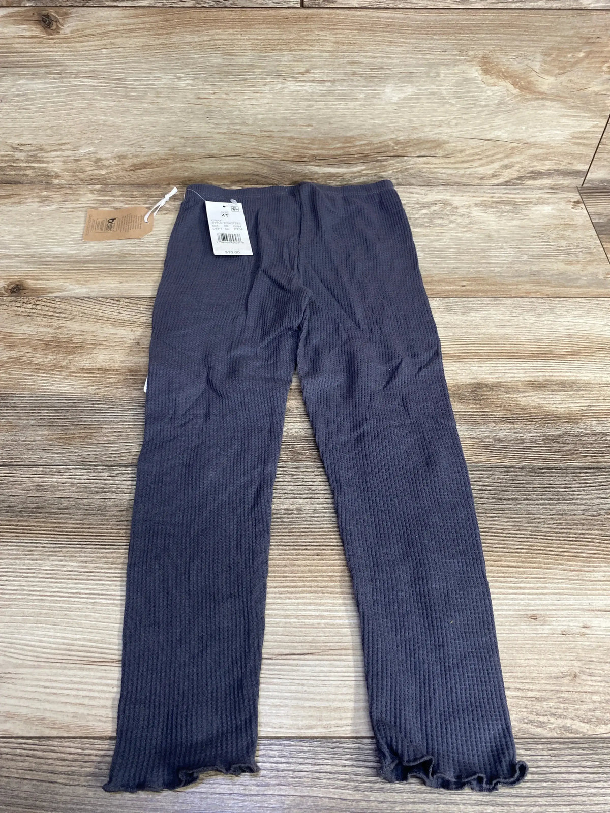 Flat lay of Grayson Collective waffle knit pull-on toddler pants (4T) showcasing waffle texture and ruffle hem on wood background