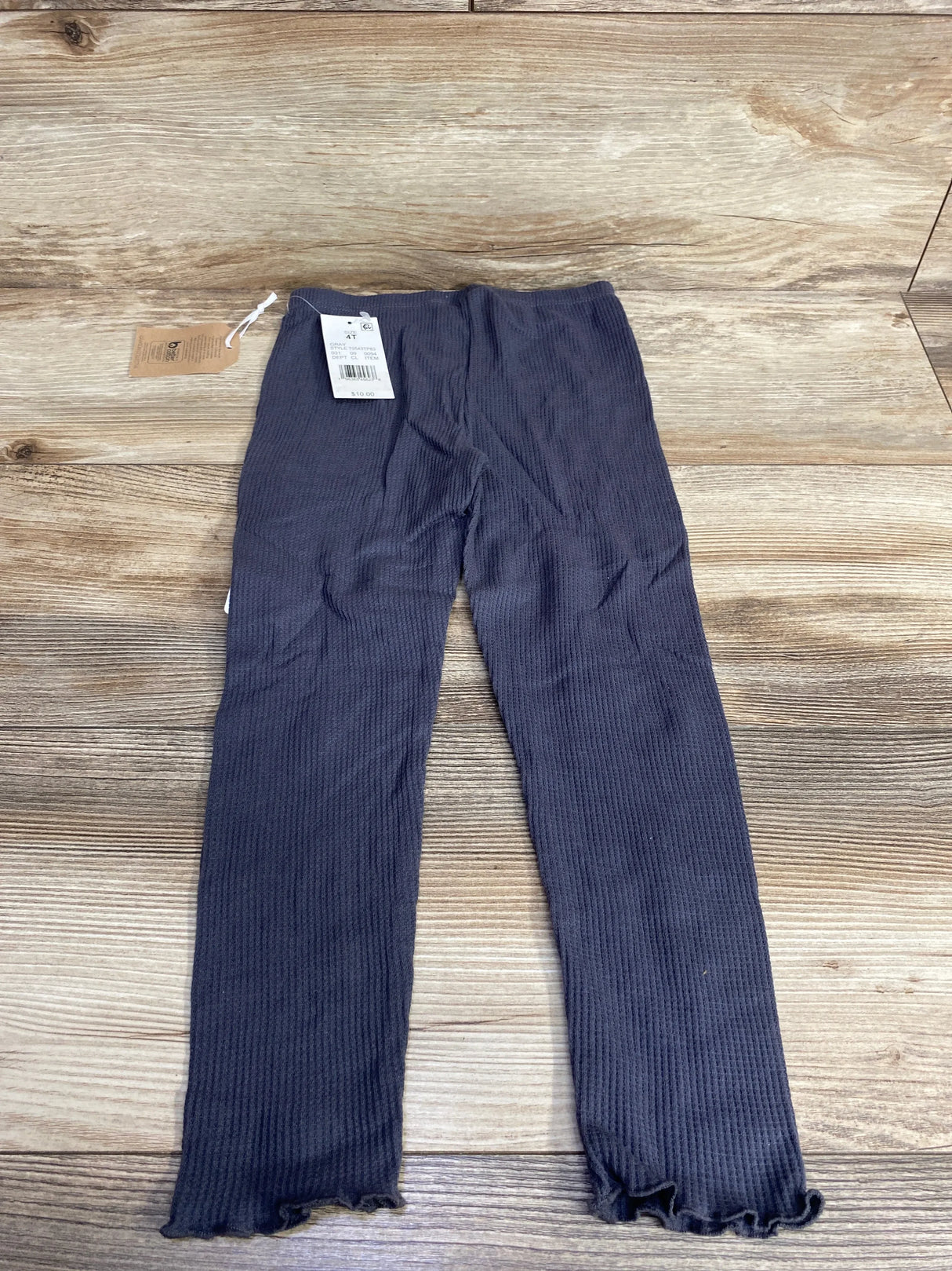 Ribbed navy blue kids leggings with ruffle hem displayed on wooden background