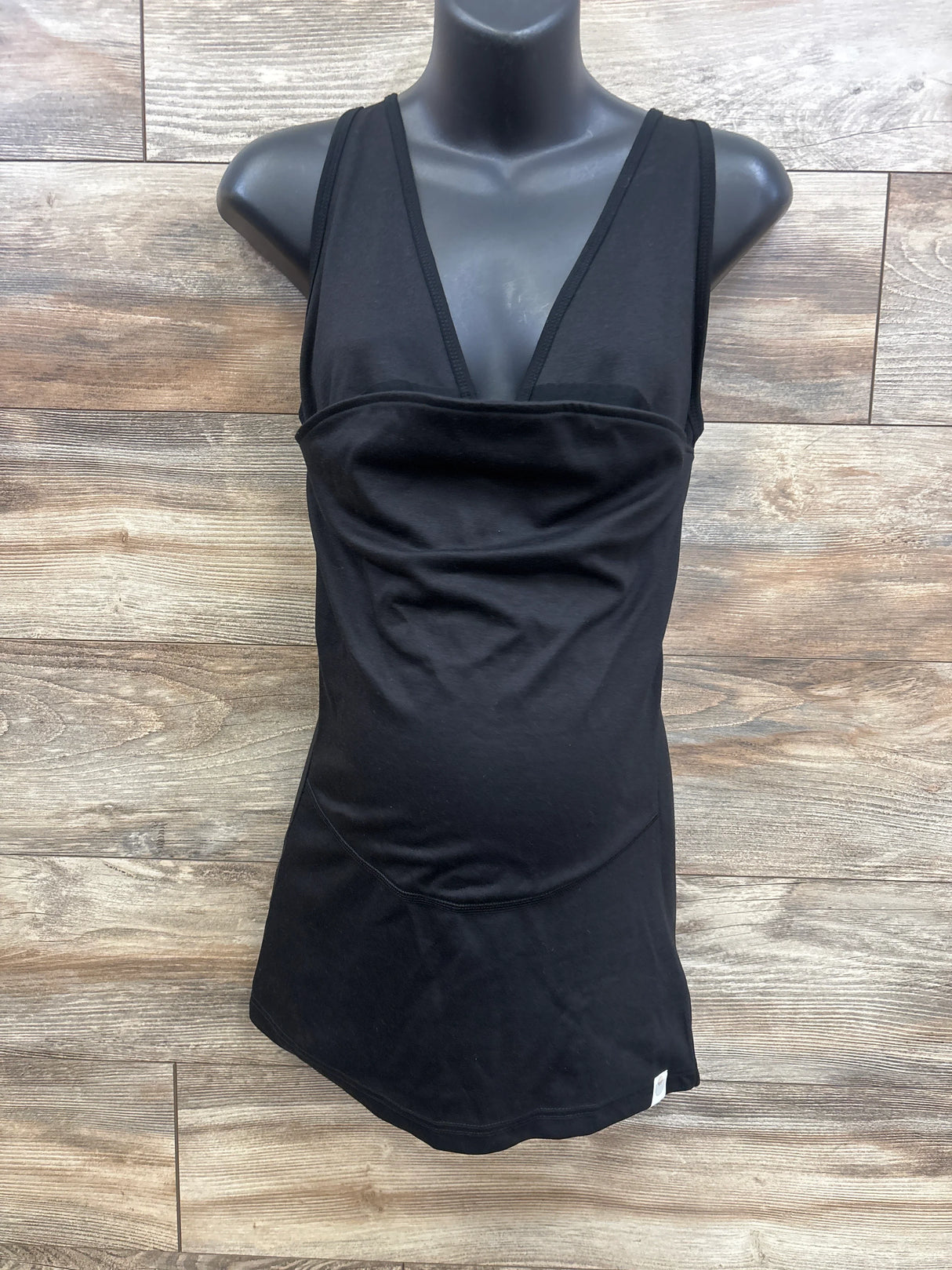 Black maternity tank top with ruched front, displayed on mannequin for expectant moms