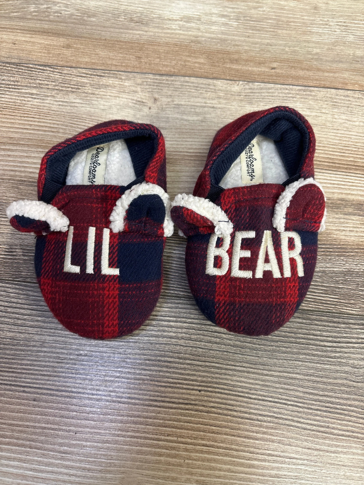 Red plaid baby booties with bear ears and 'Lil Bear' text on wooden floor