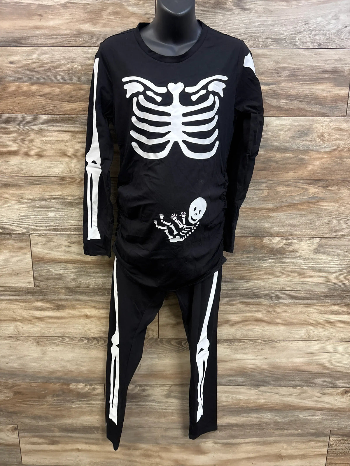 Front view of Motherhood Maternity black skeleton maternity 2-piece set with white bone prints and baby skeleton on ruched belly