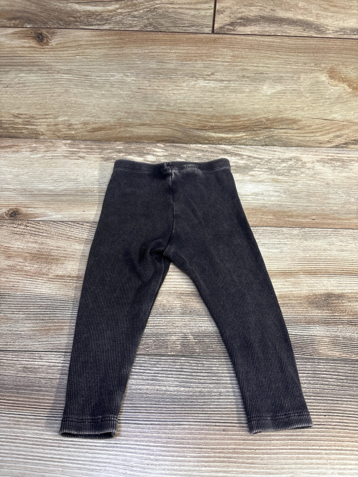 Flat lay of Cat & Jack ribbed grey baby leggings showing ribbed texture and elastic waistband on light wood background
