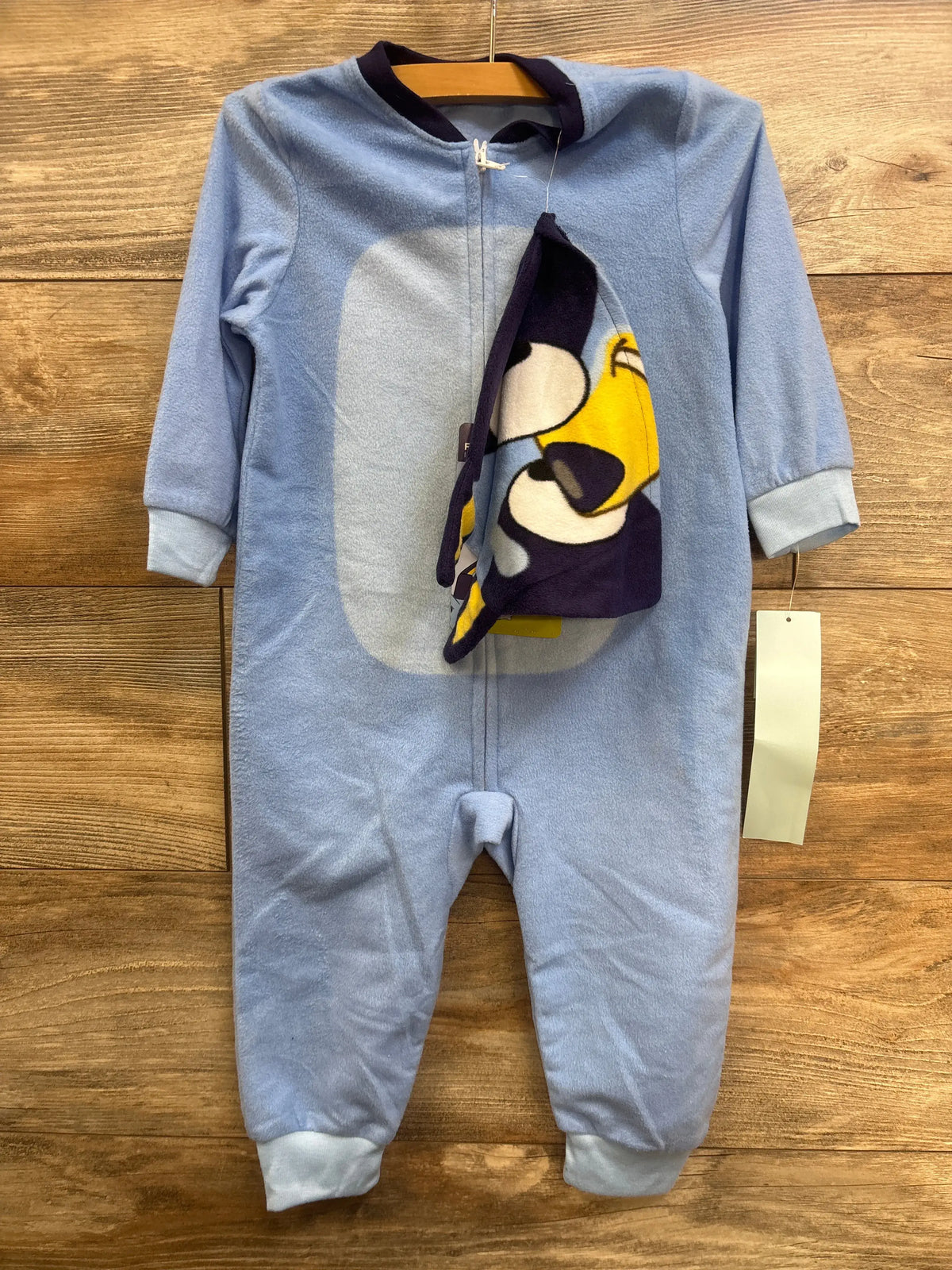 Front view of blue Bluey 2pc plush sleeper and hat set with half-front zipper, hood, and footless bottoms on wood background