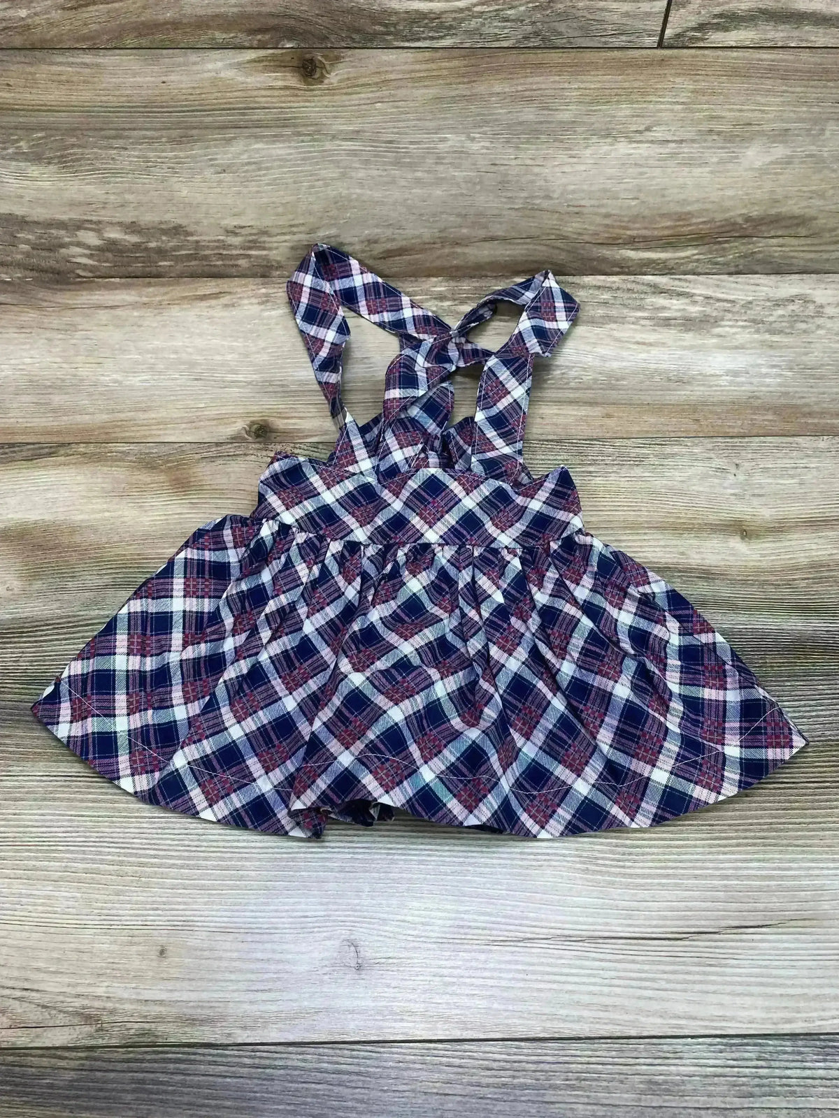 Front view of toddler suspender plaid skirt size 18 months in navy and pink with adjustable shoulder straps and pleated skirt on white background
