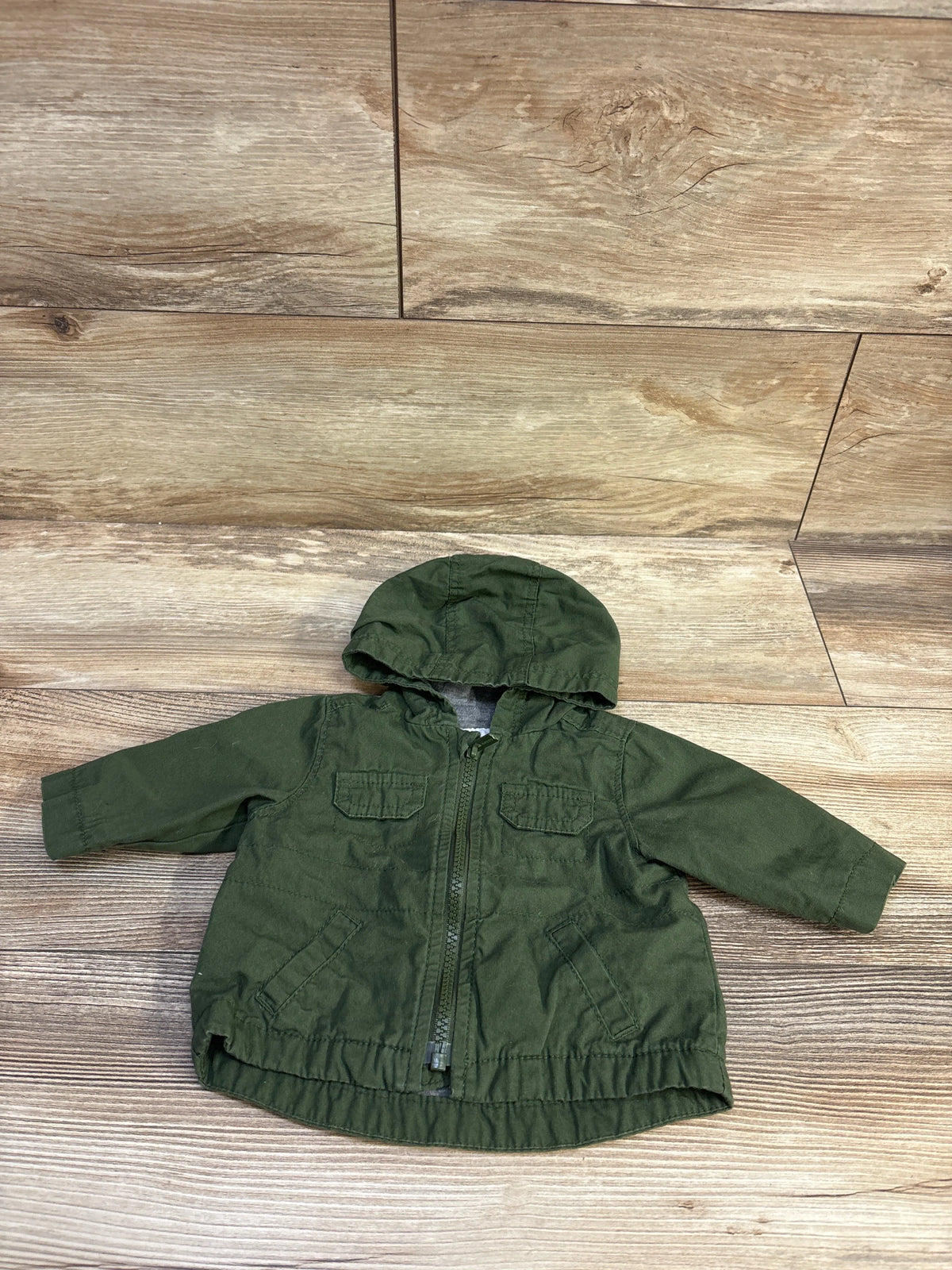 Old Navy hooded utility jacket in green for infants, size 0-3m, on a wood-grain surface.
