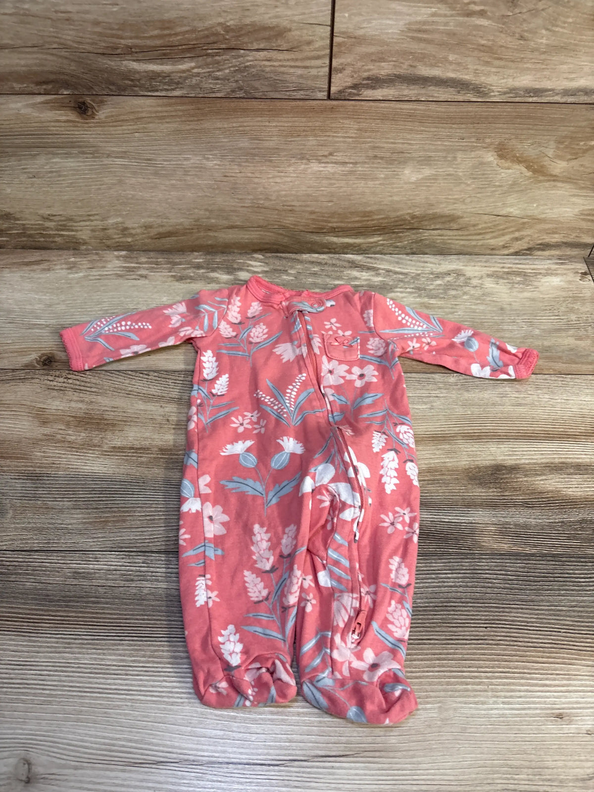 Carter's pink floral baby sleeper for infants, size 3m, on a wooden background.