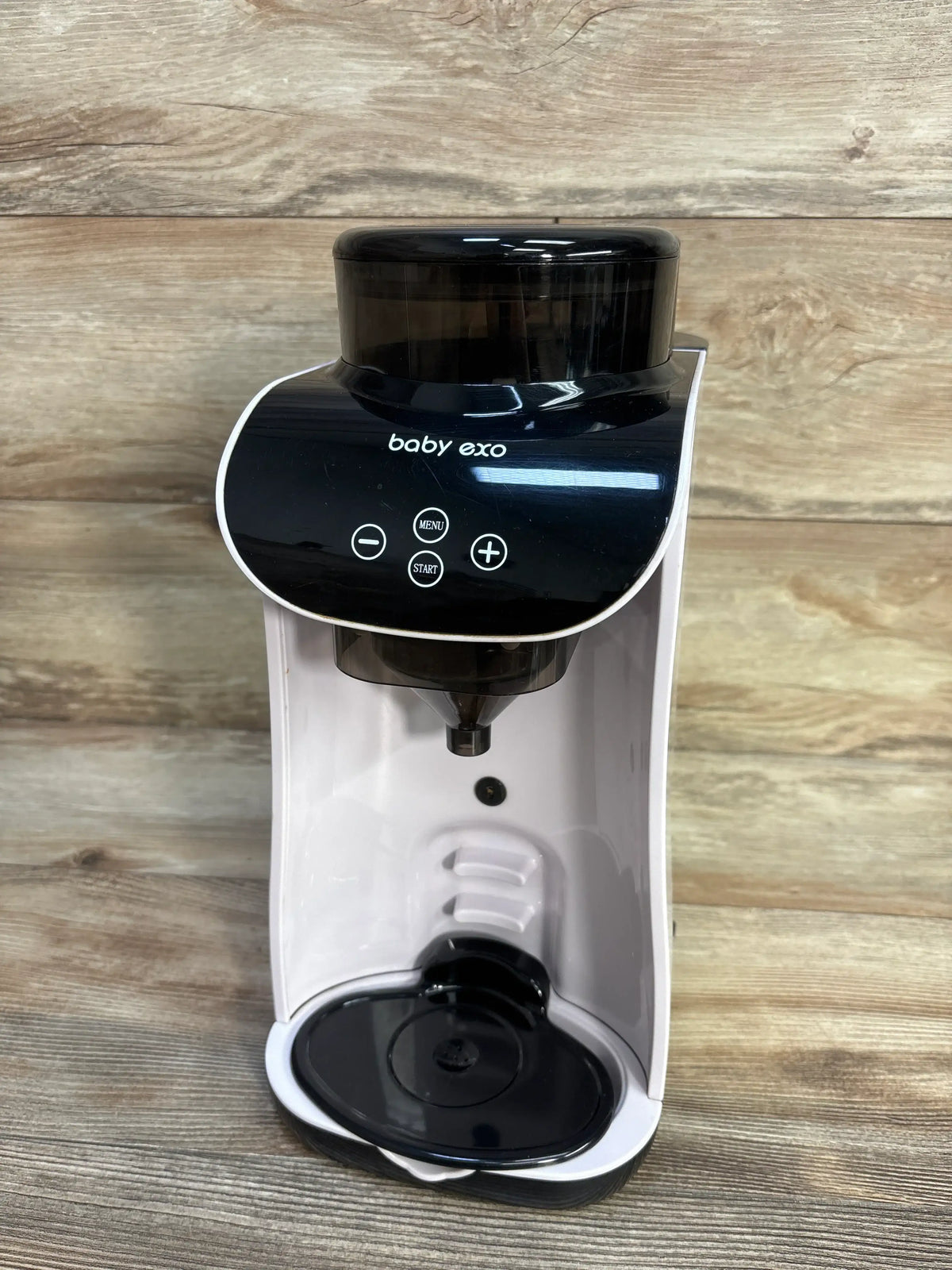 Front view of Baby EXO Smart Formula Maker/Dispenser showcasing the dispensing nozzle and control panel on a wood background
