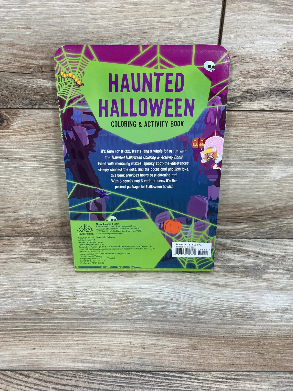 Back view of Haunted Halloween Coloring & Activity Book showcasing the bold green title and illustrated spooky cover on wooden floor