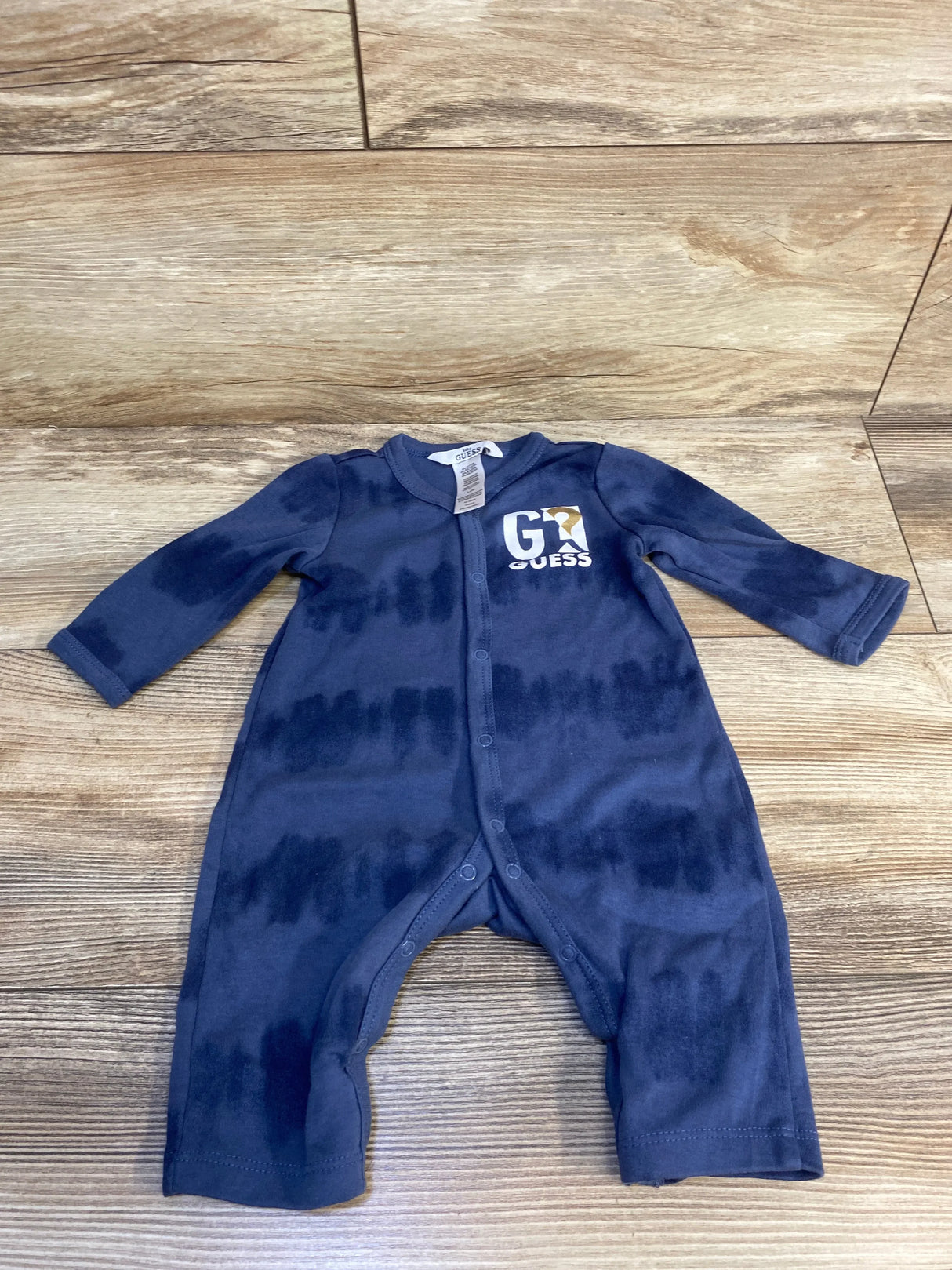 Navy blue baby romper with long sleeves and front snaps, featuring Guess logo on chest