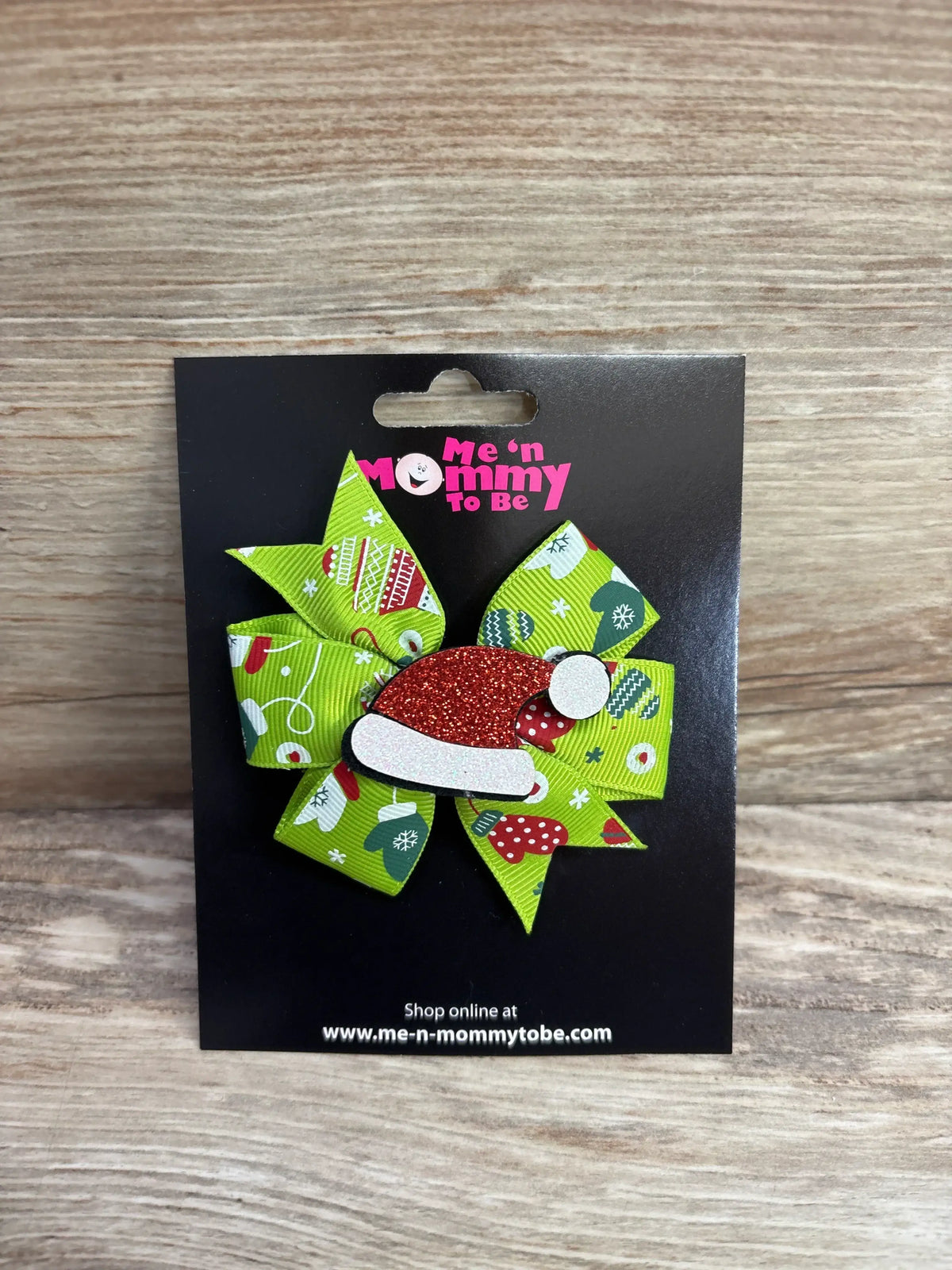 Festive green holiday bow with Santa hat accent, perfect for kids' Christmas outfits and seasonal hair accessories.