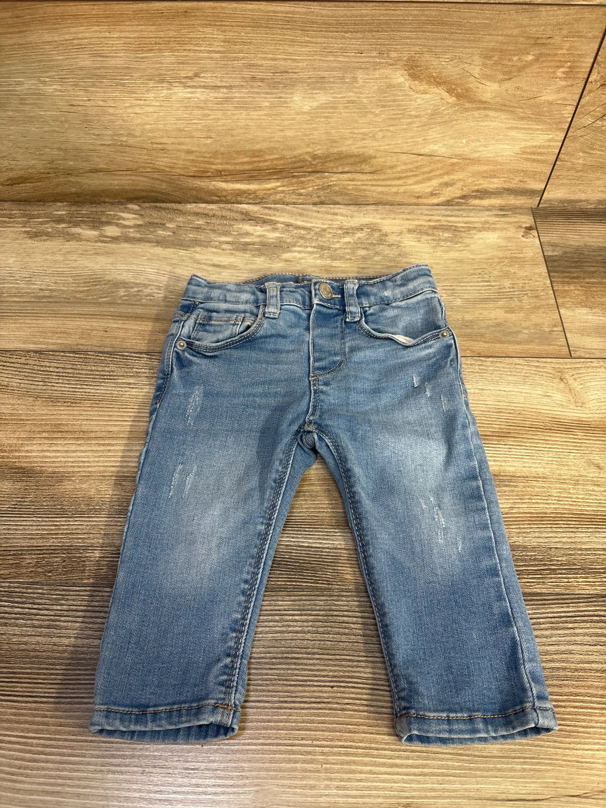 Front view of Zara blue denim jeans for ages 3 to 6 months showing pockets, belt loops, button closure, and distressed details