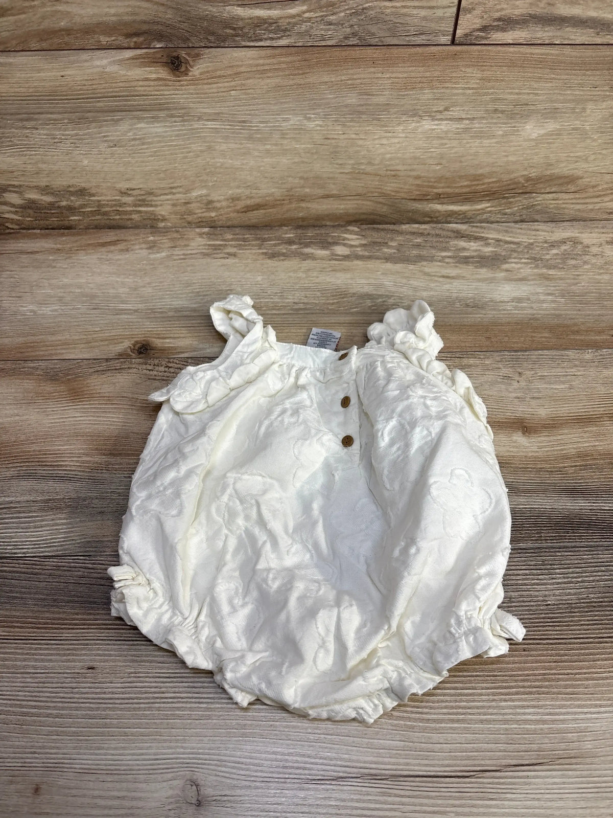 Front view of Haute Hippie ivory baby bubble romper size 6-9m with puff sleeves on white