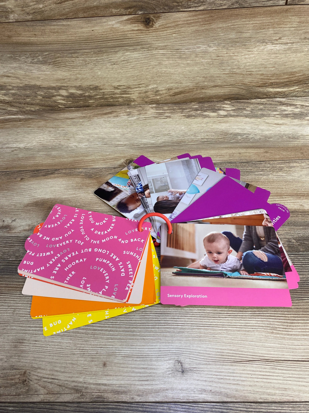 Colorful baby activity and sensory exploration flashcards fanned out on wooden surface