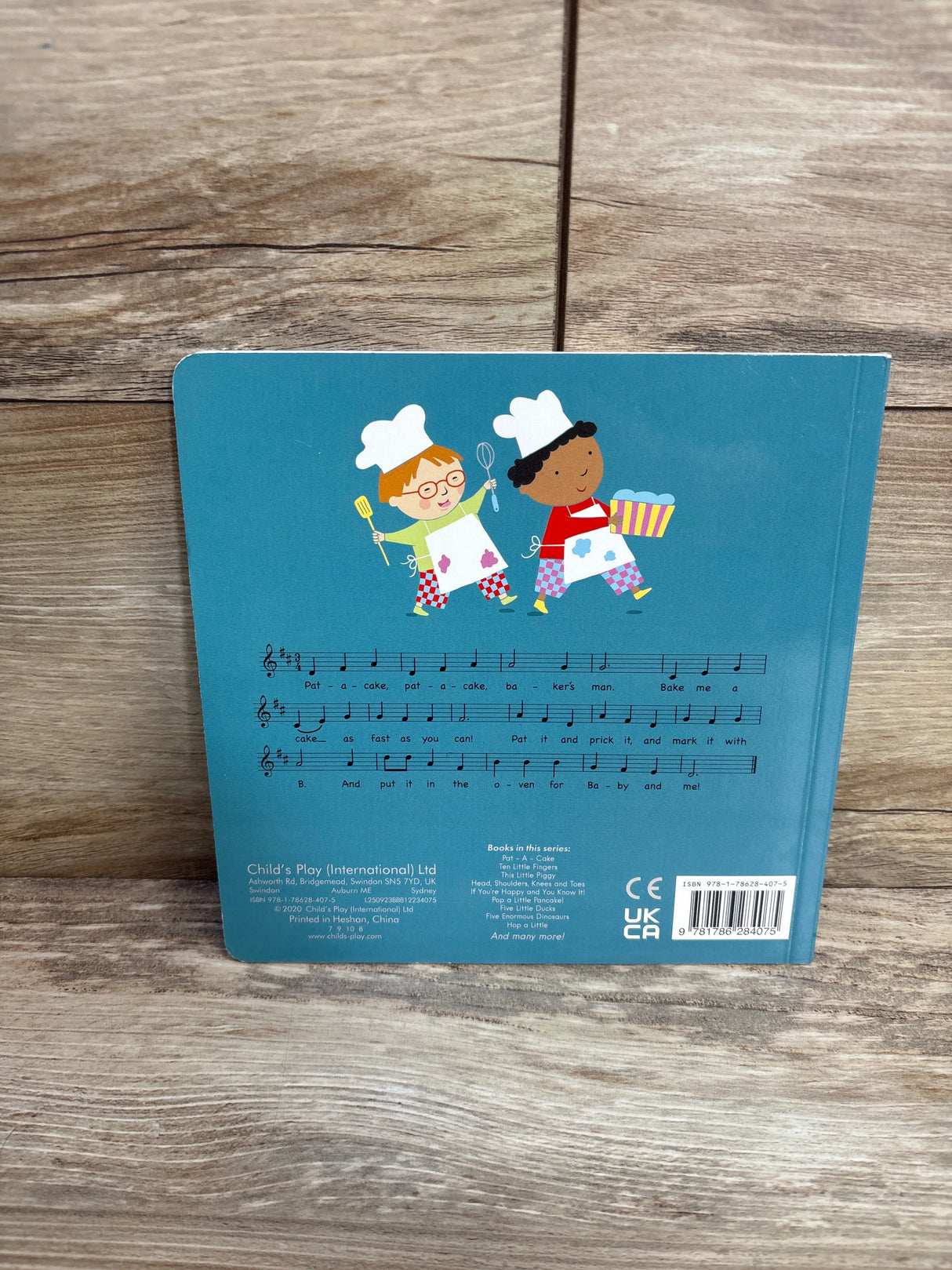 Back cover of children's book with two cartoon chefs, musical notes, and wood background