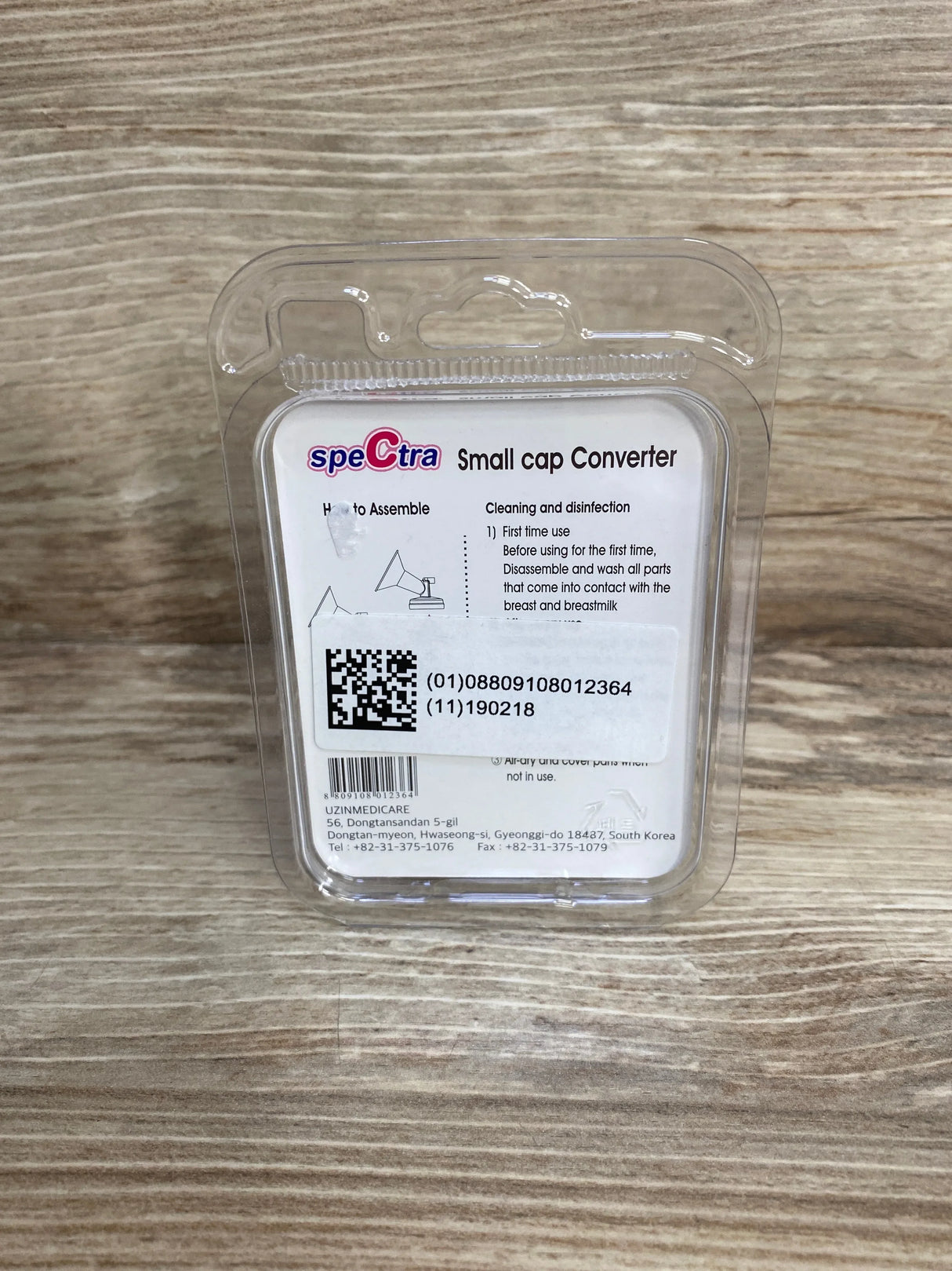Front view of Spectra small-to-wide neck cap adapter packaging showing 'Small cap Converter' label and QR code on wood background