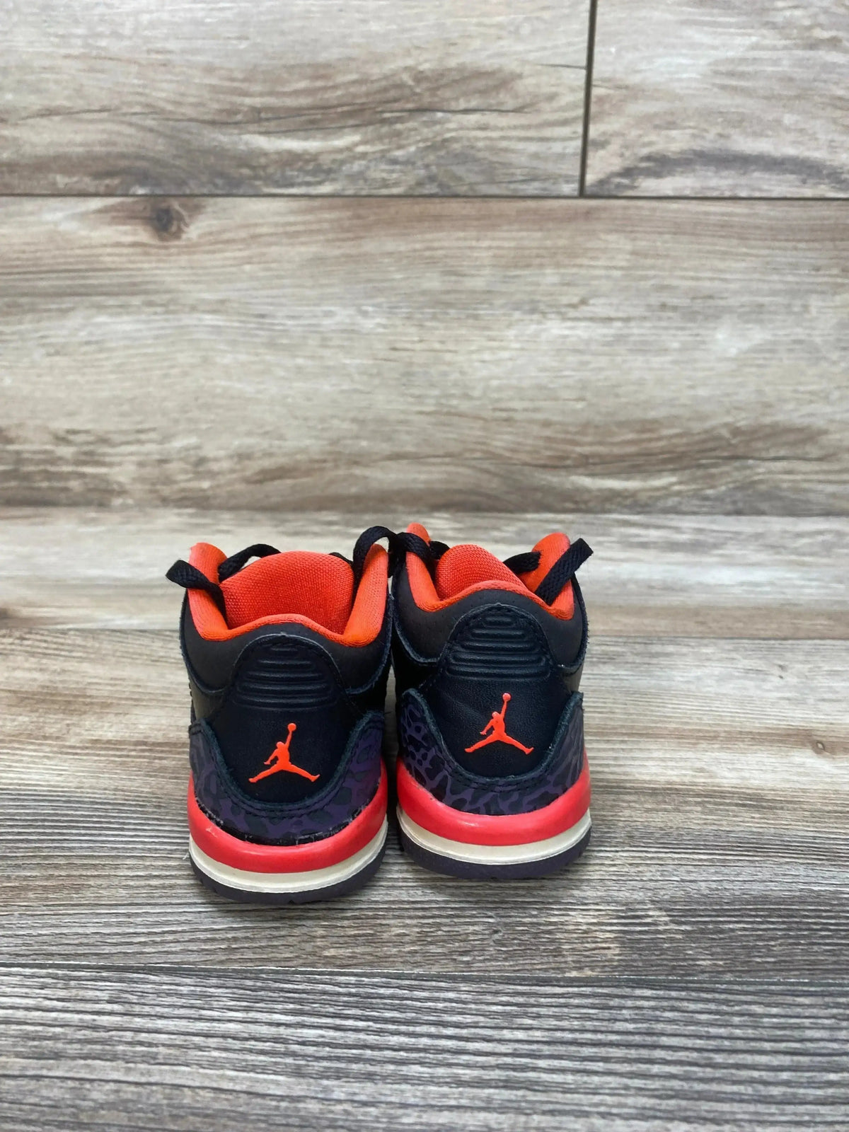 Side view of toddler Air Jordan 3 Retro TD sneakers, black with crimson accents, size 5C, leather on white