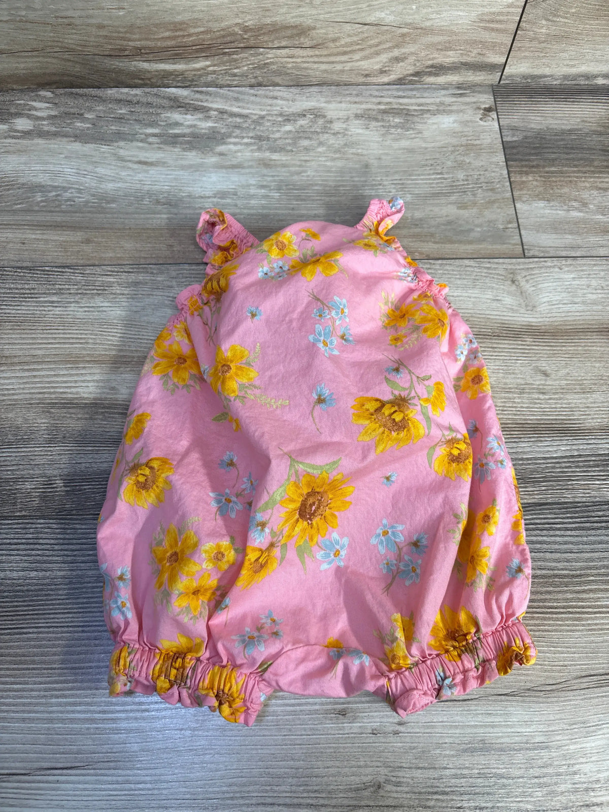 Overhead view of Old Navy sleeveless floral shortie romper showcasing pink floral cotton fabric and ruffled leg openings