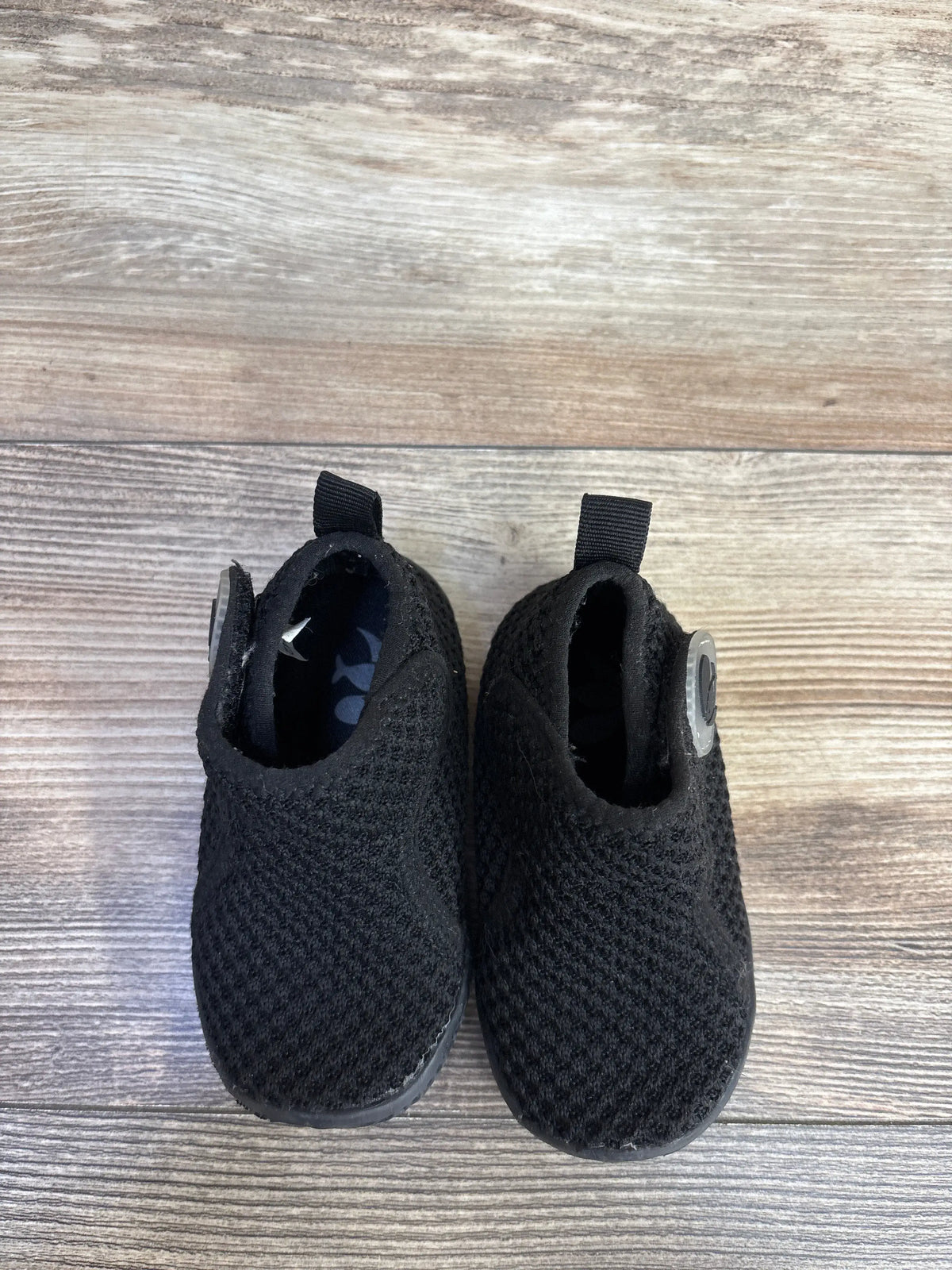 Top view of FEETCITY black high-top mesh sock shoes in size 6/7C showcasing pull tabs on a wood grain surface