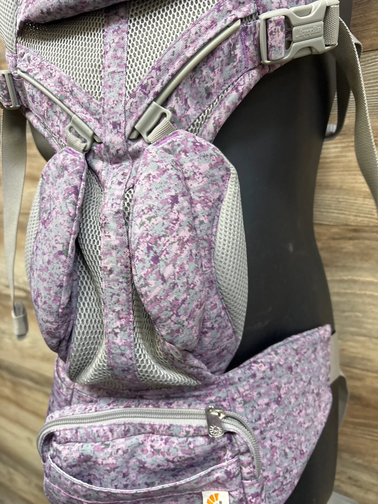 Front close-up of Ergobaby Omni 360 carrier in pink digi camo with mesh panels, padded straps, and zippered waist pocket