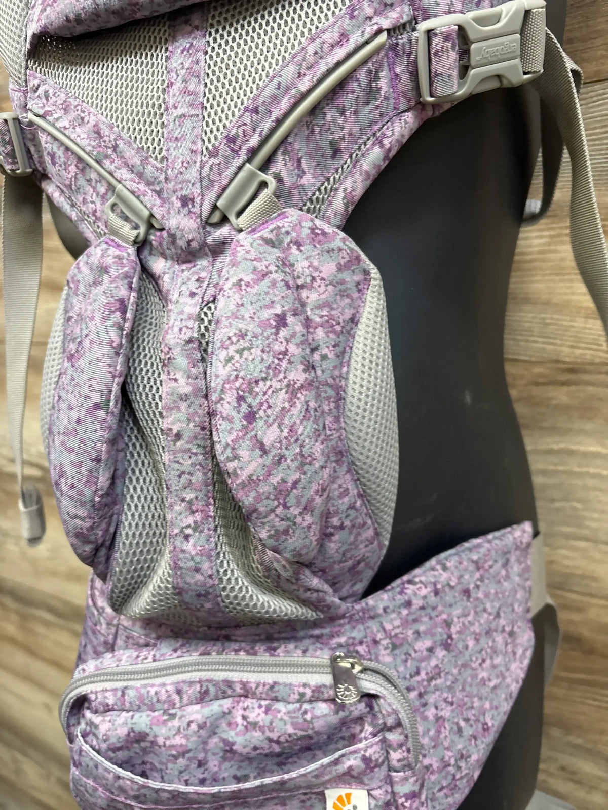 Front close-up of Ergobaby Omni 360 carrier in pink digi camo with mesh panels, padded straps, and zippered waist pocket