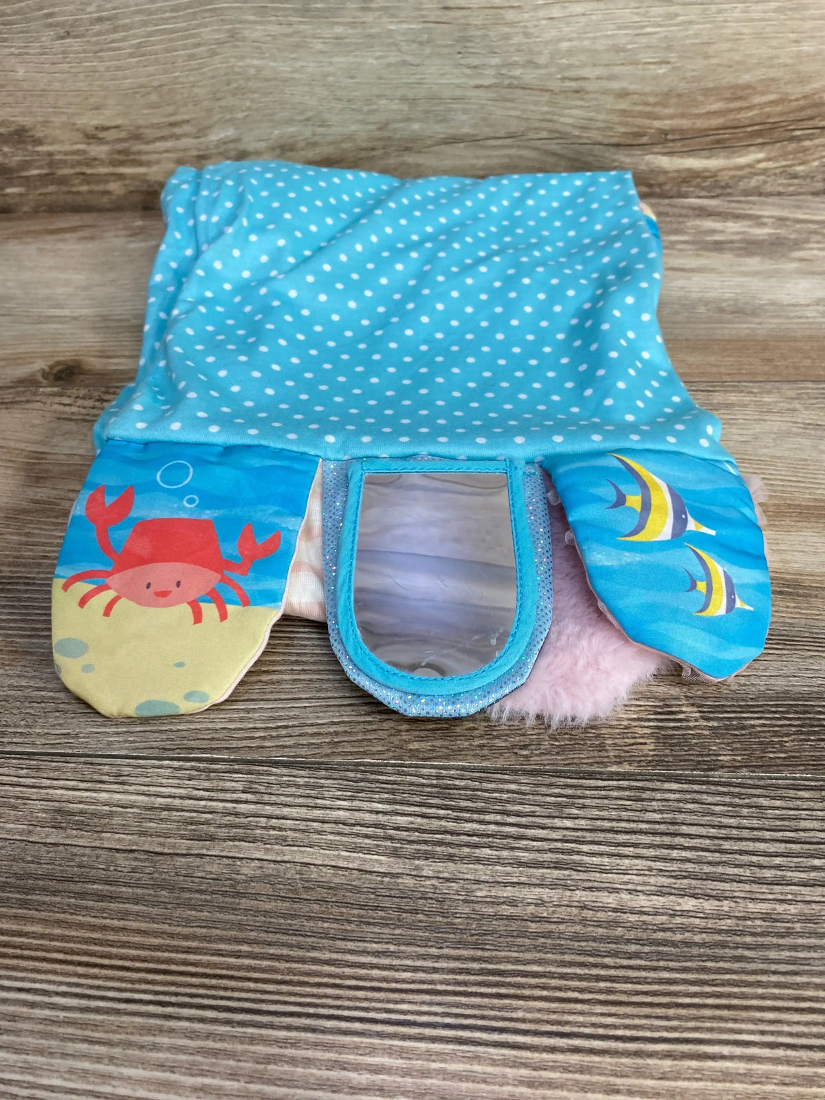 Front view of Demdaco Activity Scarf showing mermaid flaps with crab and fish, center sensory mirror and pink plush backing