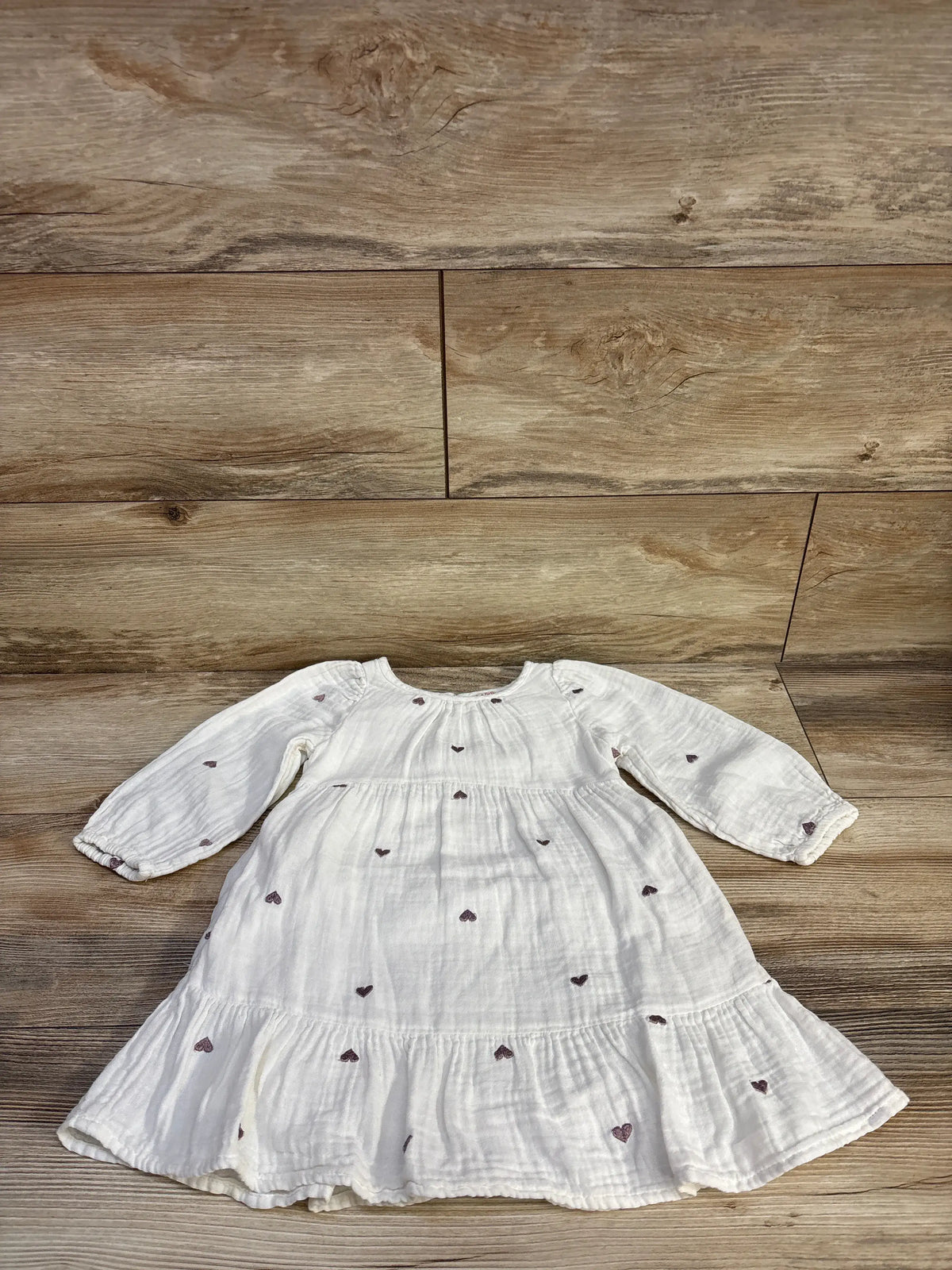 Front view of Cat & Jack white gauze tiered dress showcasing embroidered hearts on wood background