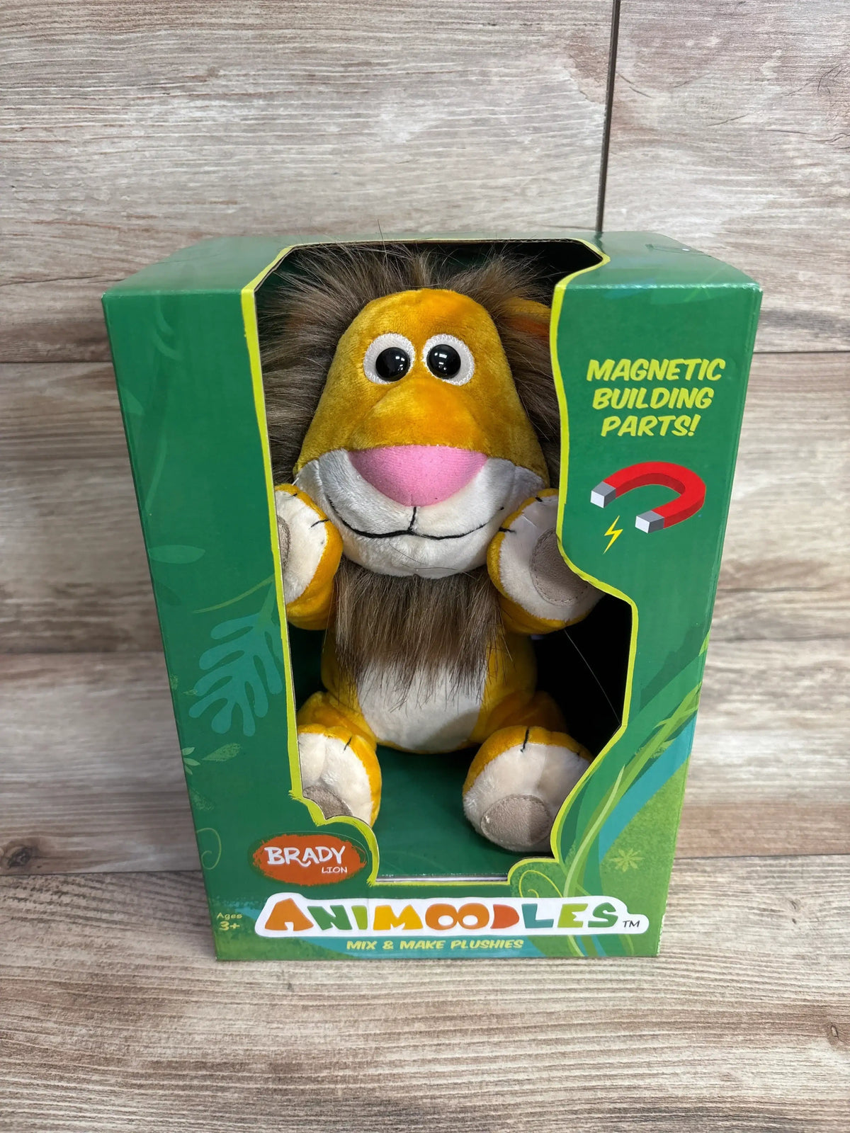 Animoodles Brady Lion plush toy with magnetic building parts in green box on wood background