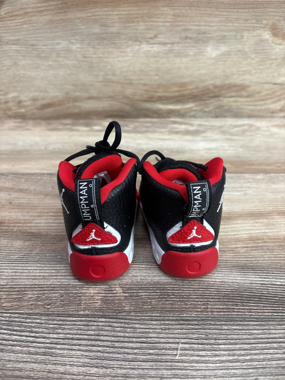 Rear view of Air Jordan Jumpman Pro TD Bred sneakers in size 4c on a wooden background.