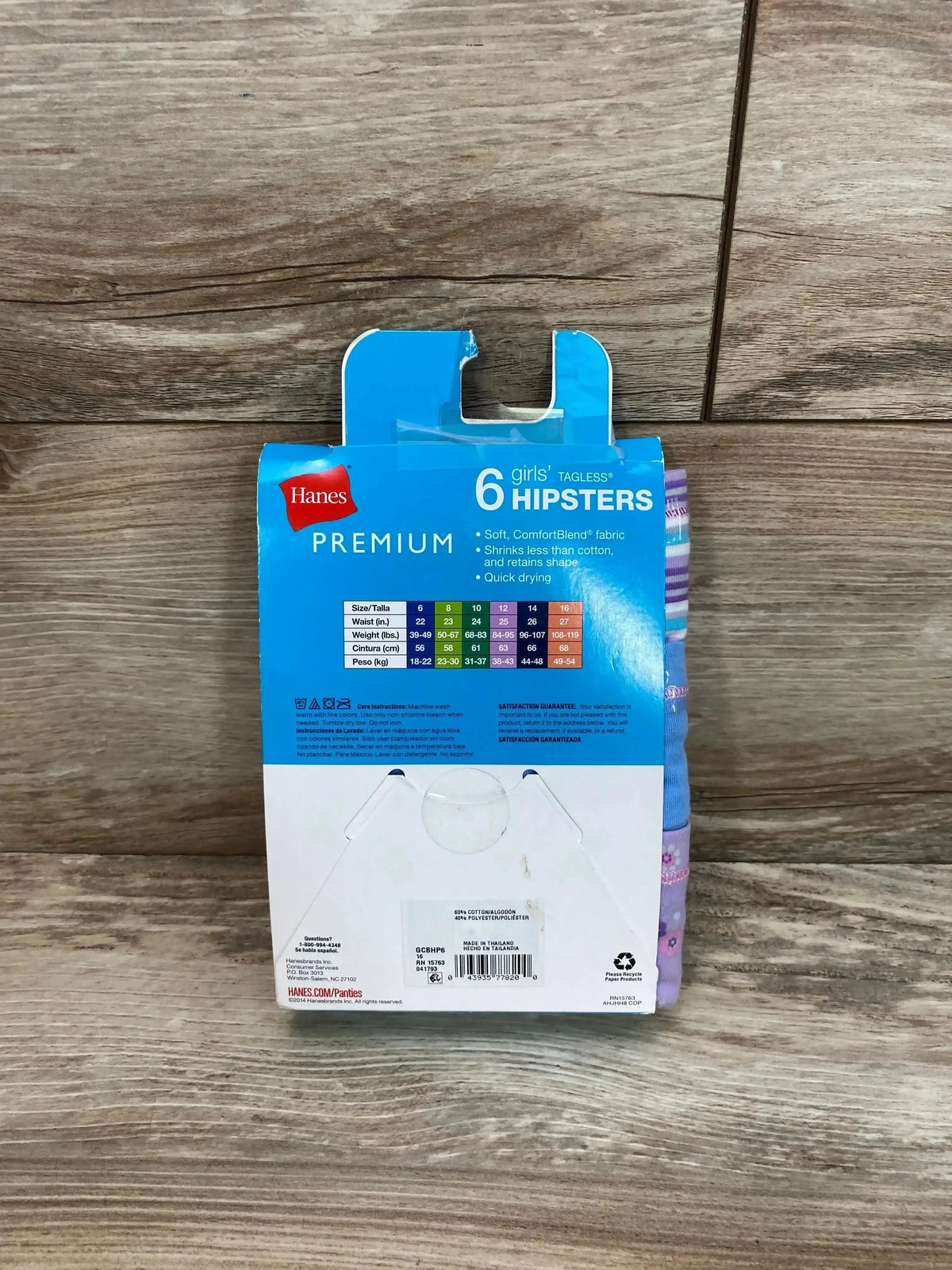 Rear view of Hanes girls' 6-pack Premium hipsters size 16 showing tagless ComfortBlend packaging on wood background