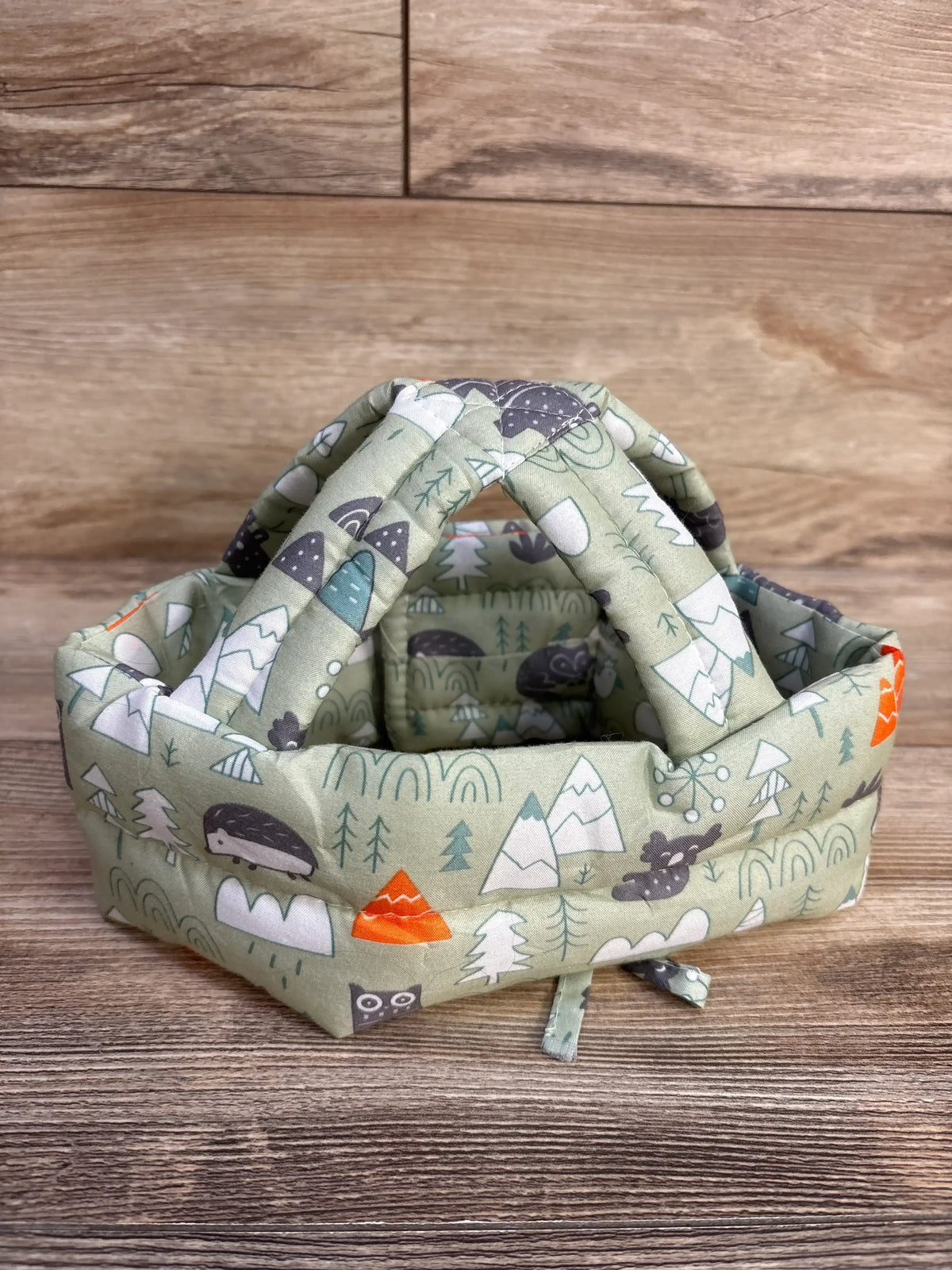 IULONEE baby head protection helmet in green with a mountain and animal print
