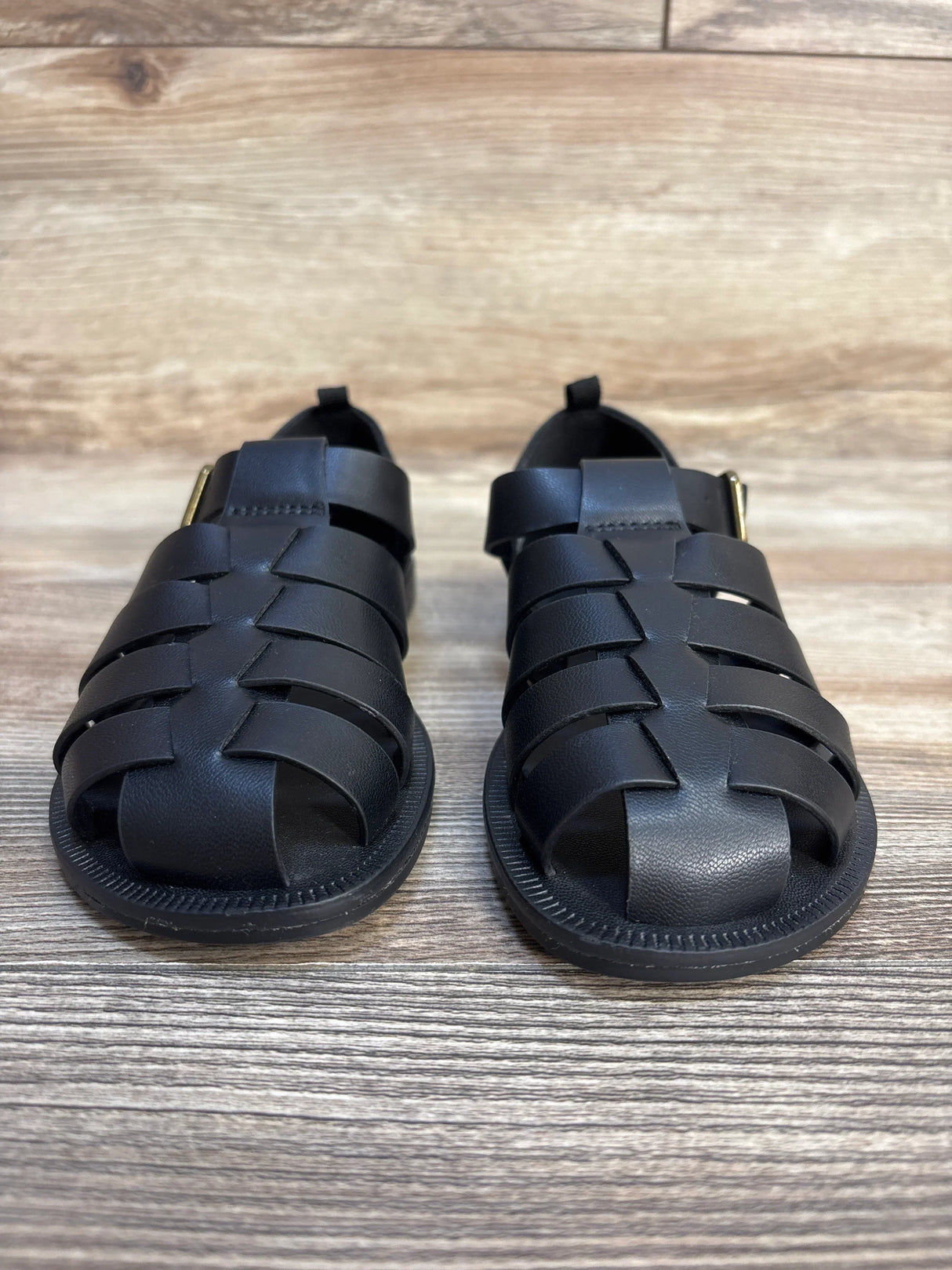 Black kids closed-toe woven sandals displayed on wooden floor