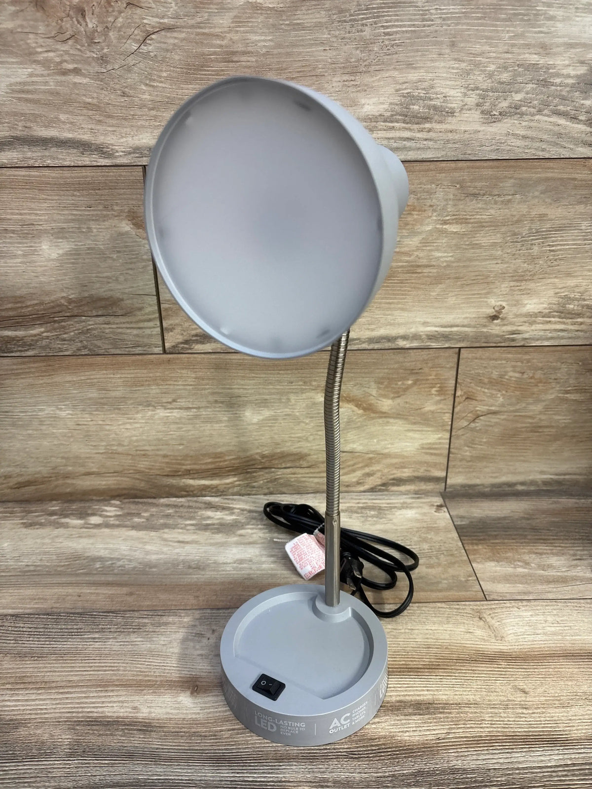 Front view of Mainstays LED Desk Lamp with Catch-All Base, Grey showcasing gooseneck and catch-all base on wood surface