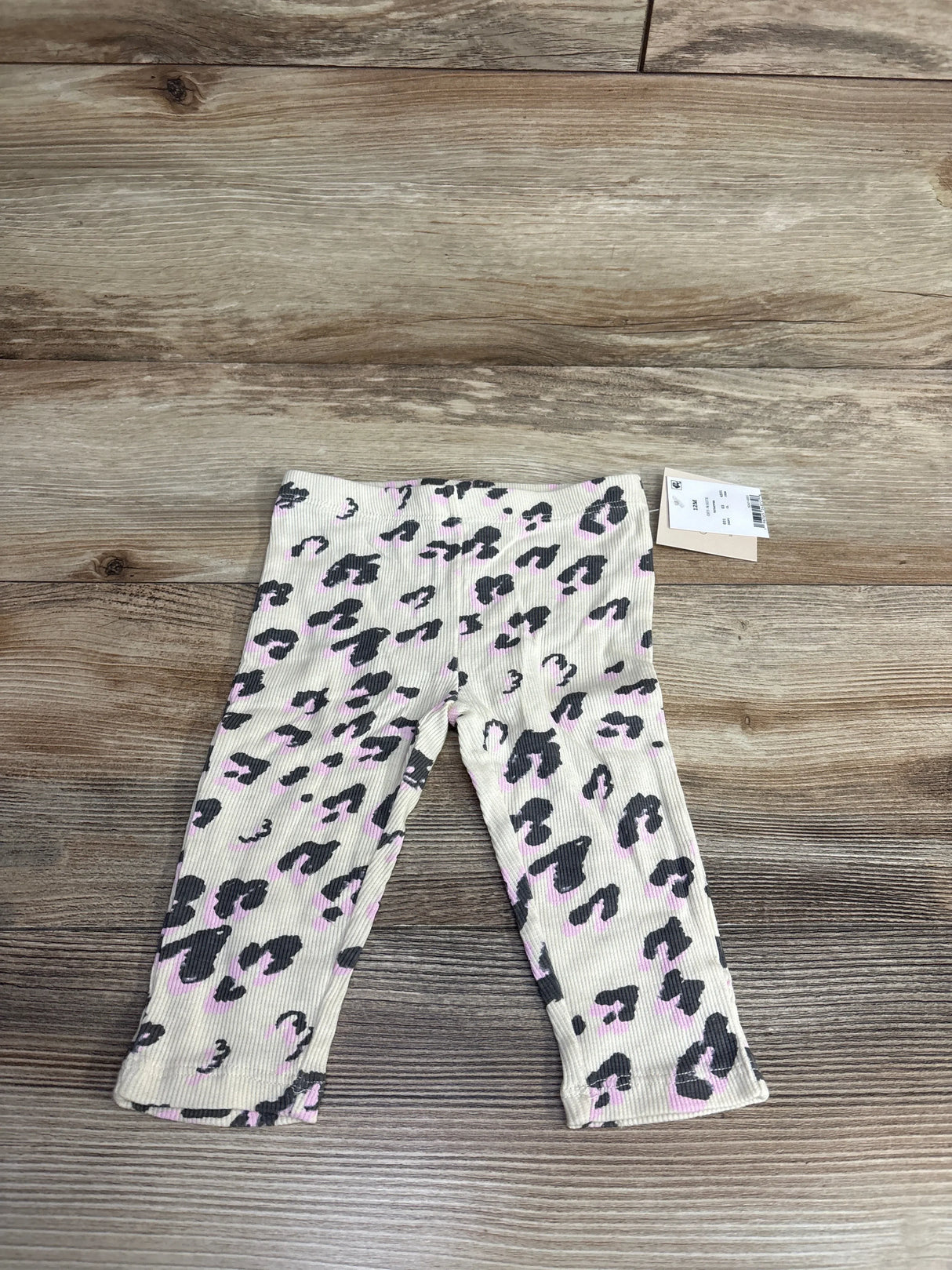 Baby girl leopard print pants with pink and black pattern on wood background