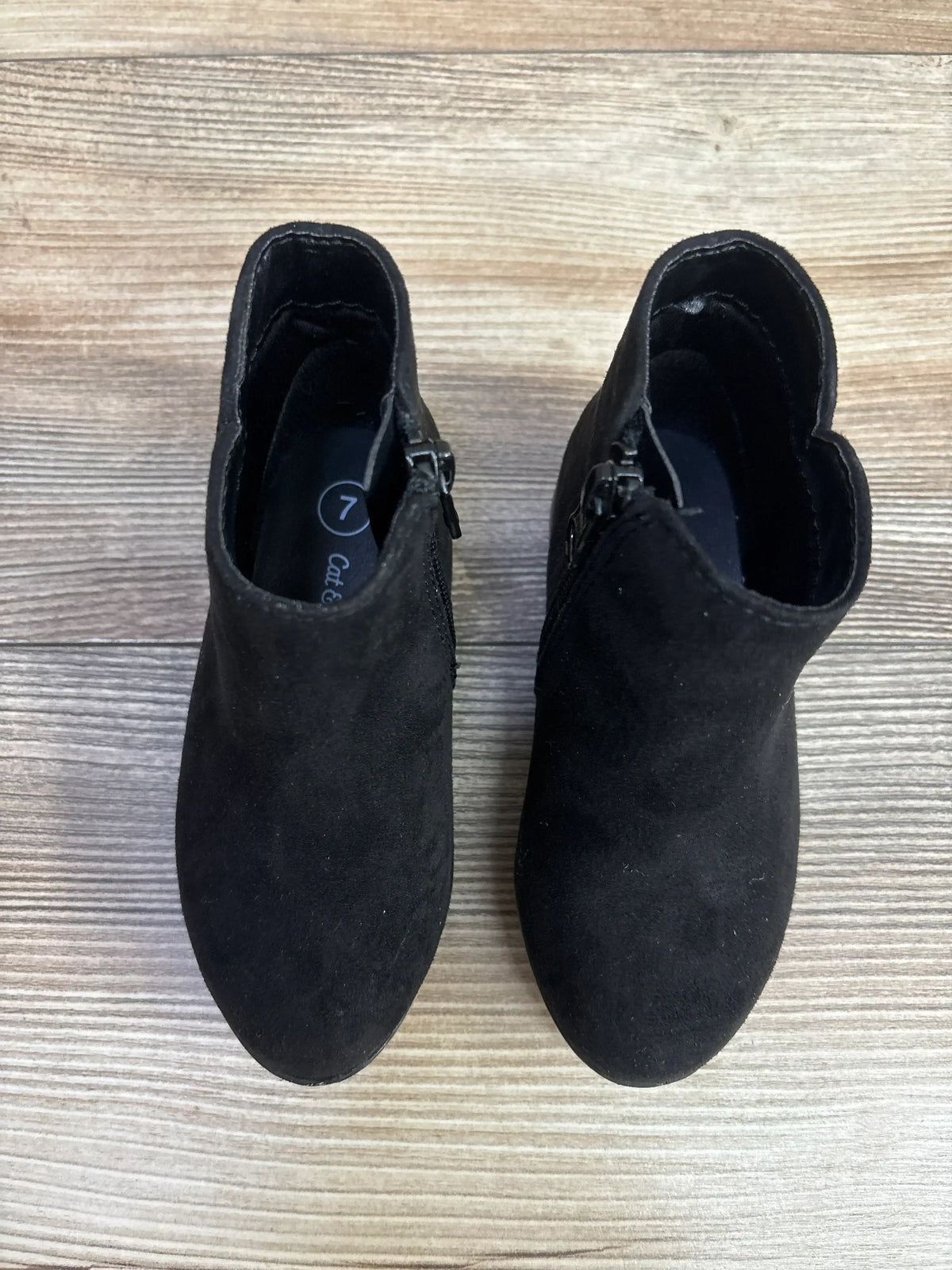 Pair of black toddler ankle boots with side zippers on wood floor, size 7, kids shoes