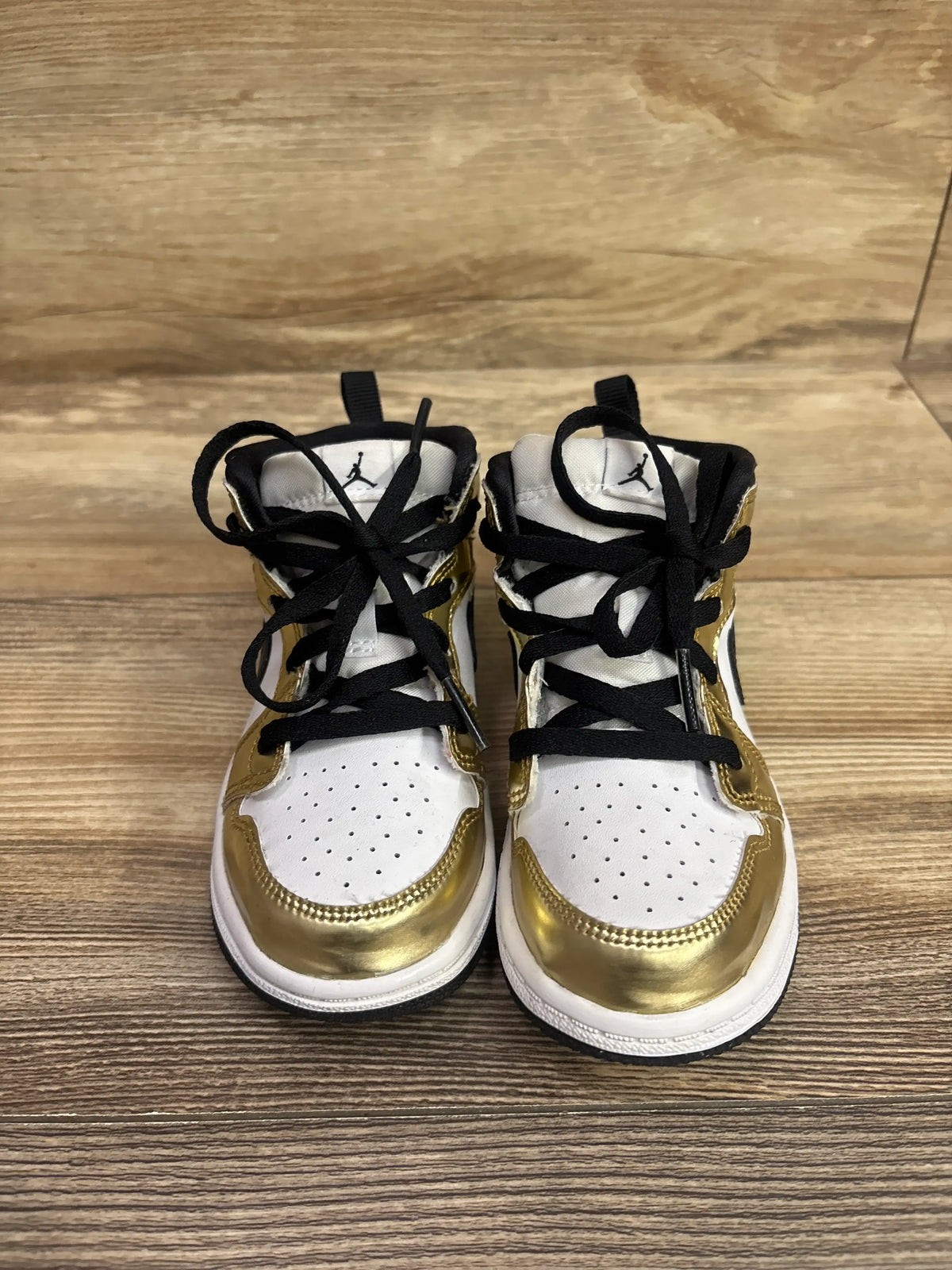 Front view of Air Jordan 1 Mid SE TD Metallic Gold sneakers showcasing white uppers, metallic gold overlays, and black laces