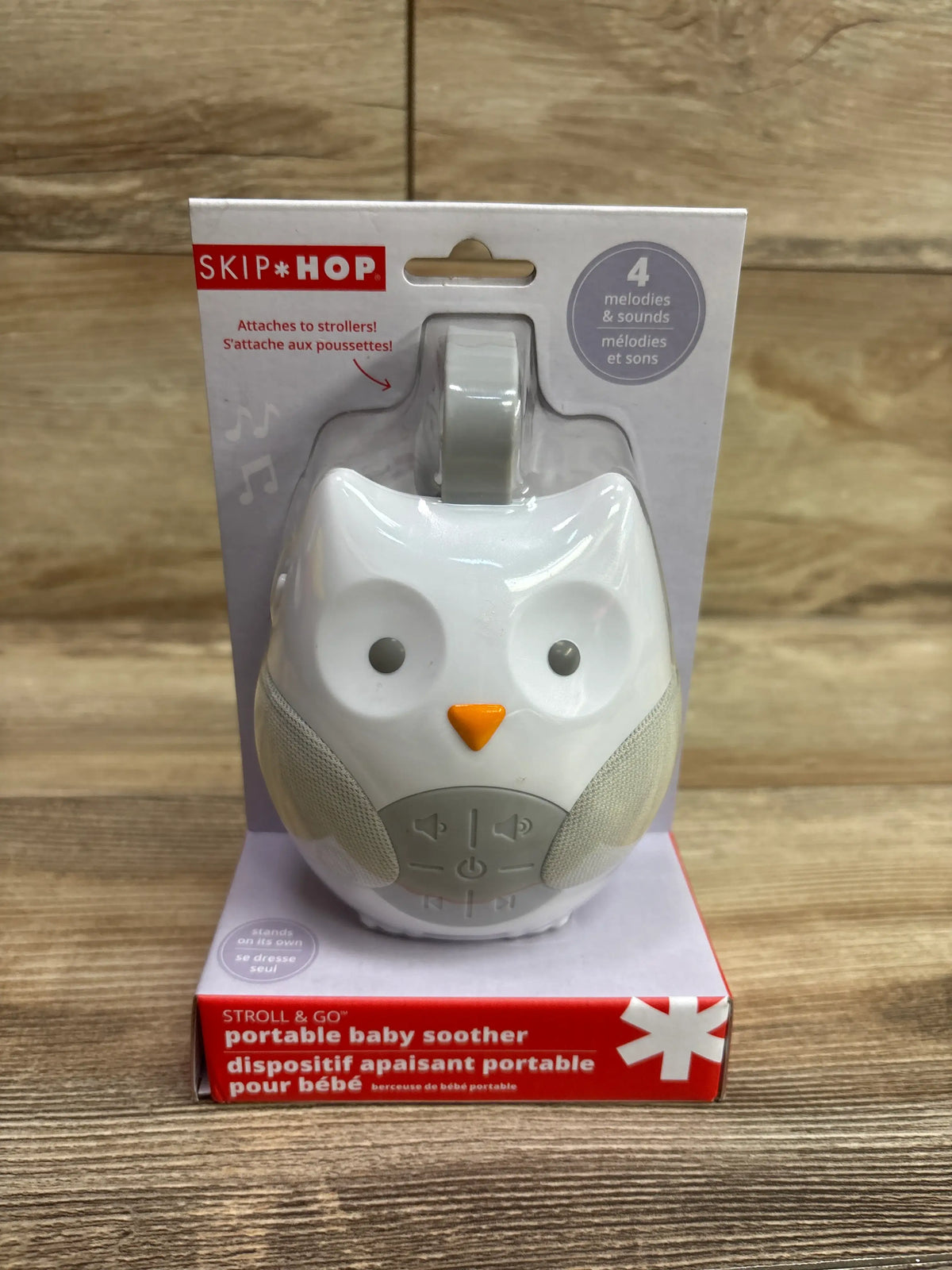 Front view of Skip Hop Stroll & Go portable owl soother with stroller attachment and four melodies in retail packaging
