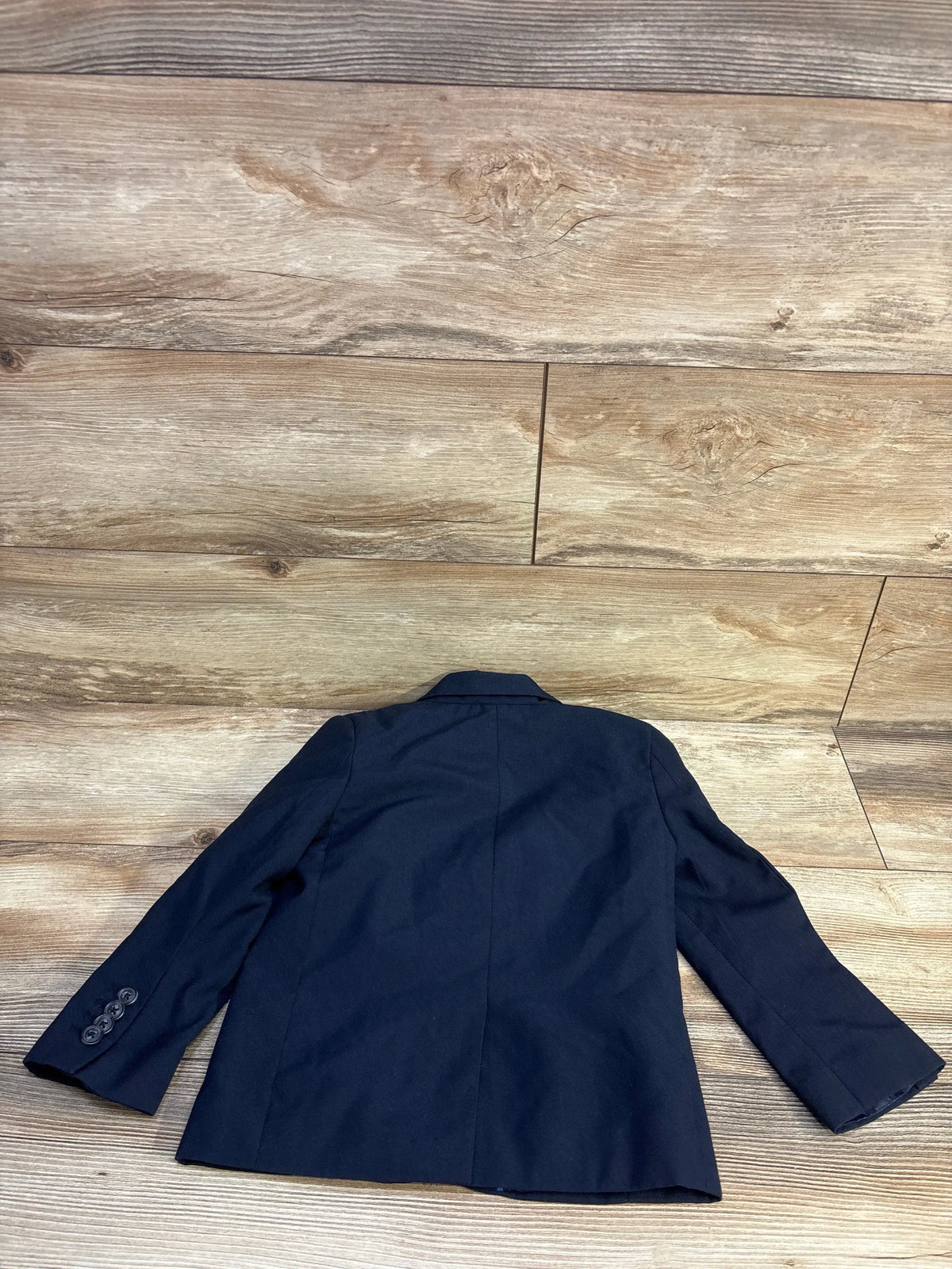 Back view of Cat & Jack toddler navy suit jacket showing center back seam and buttoned cuffs on wood floor