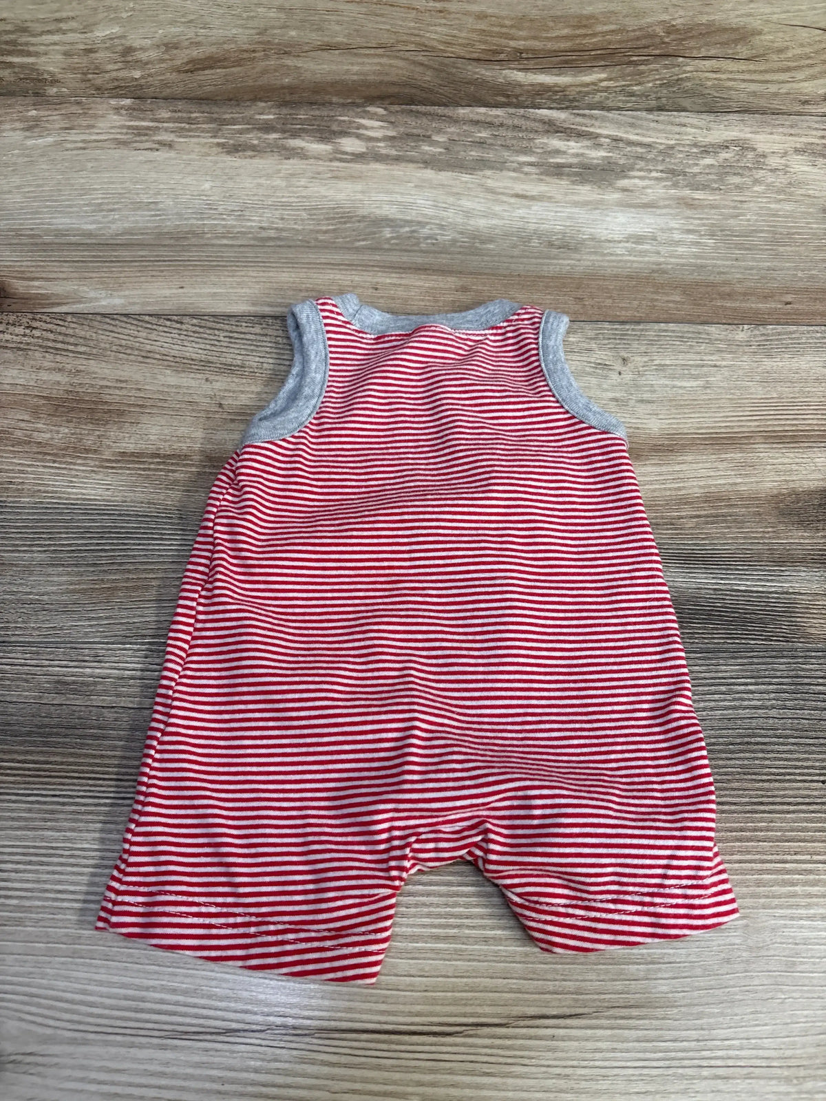 Flat-lay back view of newborn Carter's red-and-white striped tank romper with gray trim on wood background