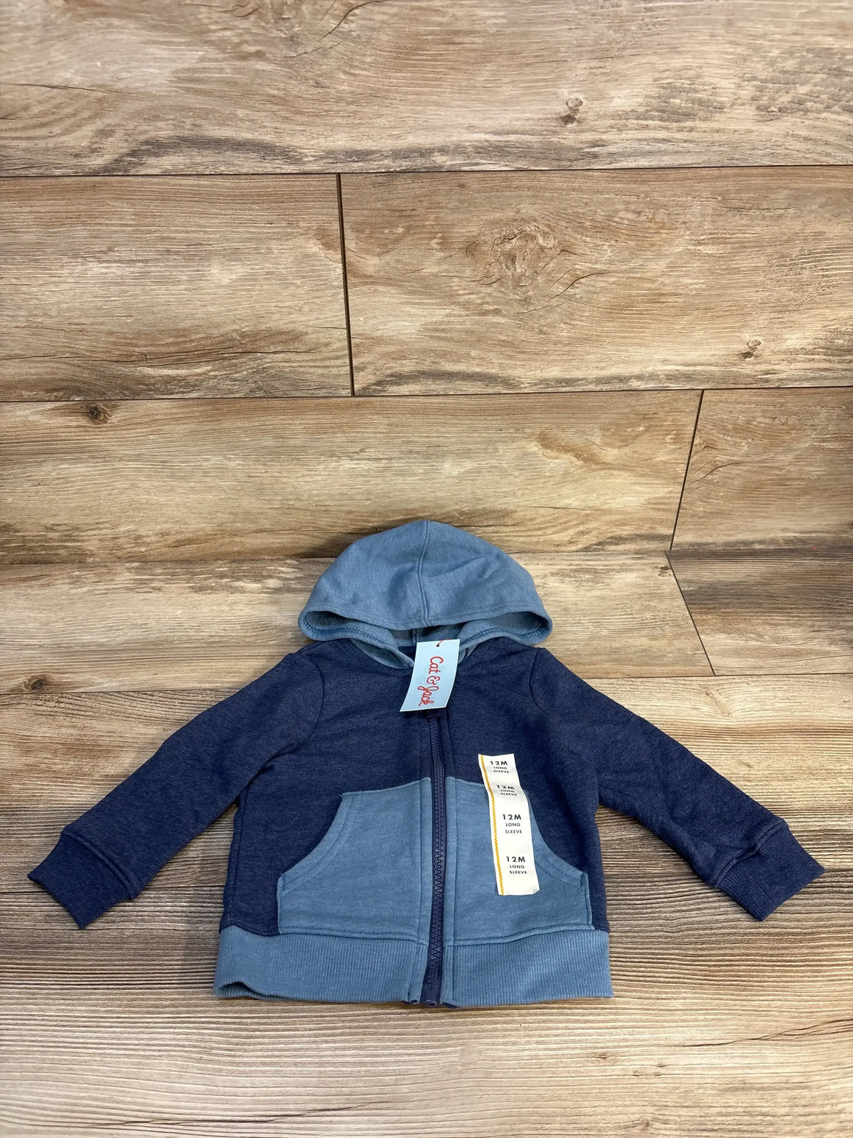 Blue and navy baby zip-up hoodie with pockets and hood for 12 months, on wood background