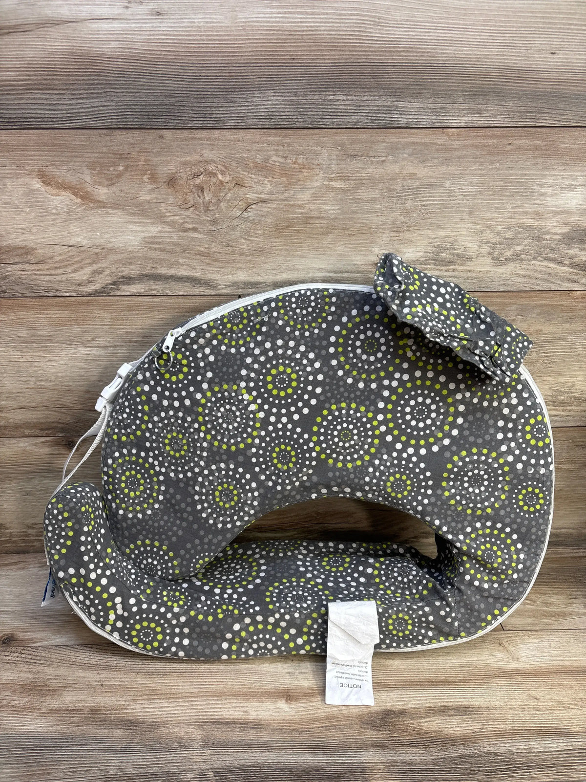 Front view of My Brest Friend nursing pillow slipcover showcasing gray fabric with white and lime circular pattern on wood background