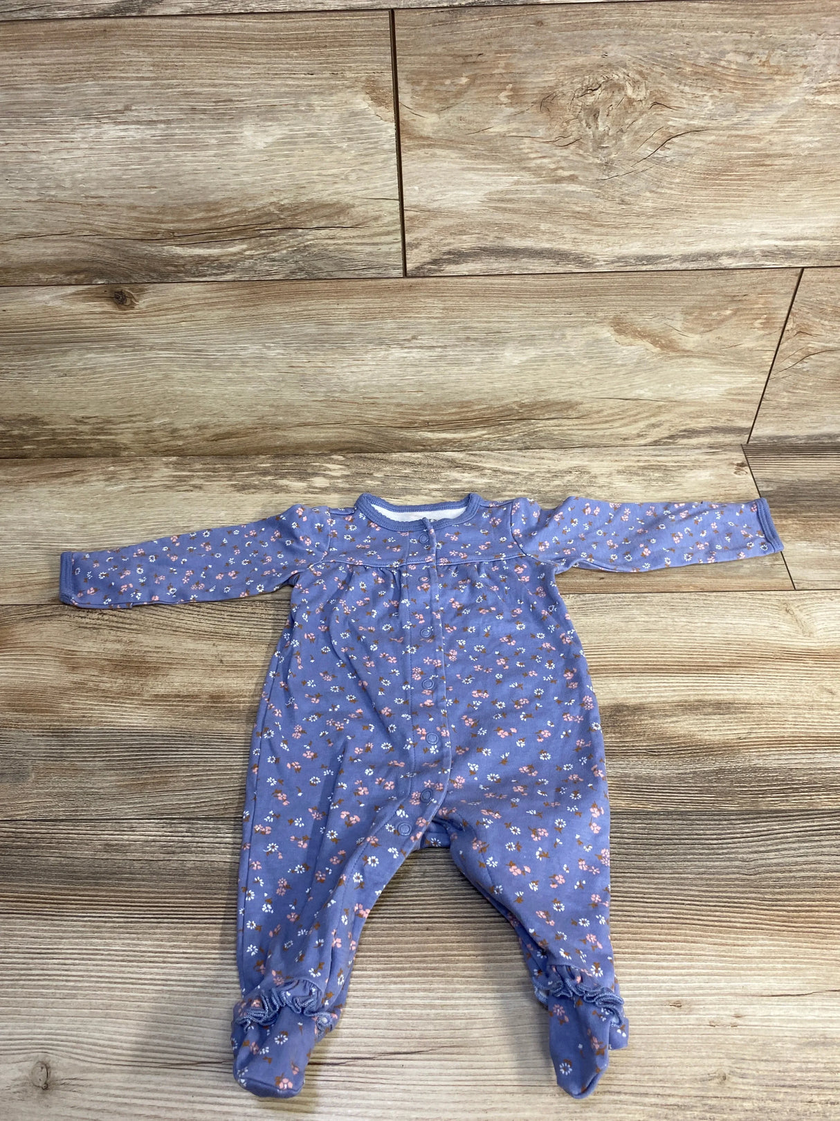 Purple floral long sleeve baby romper on wood background